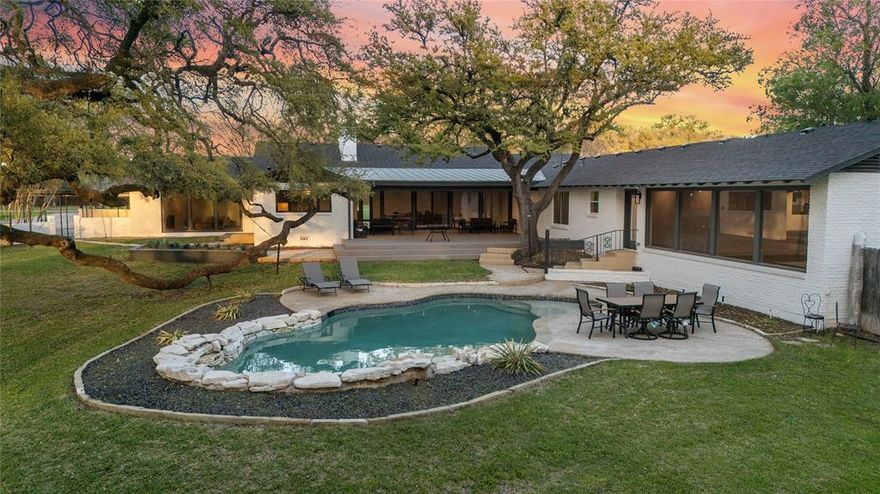 Complete Remodel by Brad Alford! This Mid Century reimagined home blends modern design with warm, natural finishes, creating a space that feels both elevated and inviting. Every detail was carefully selected, from the Garapa wood ceilings, Oak wood floors and layered mix of custom cabinetry, natural stone, and soft neutral tones throughout. The kitchen serves as a true centerpiece, featuring natural Terrazzo flooring, a dimensional backsplash, 48 inch sink system, 2 Miele dishwashers; a seamless combination of painted and walnut cabinetry that adds depth and character. Just beyond, the home opens into beautifully defined yet connected living and dining spaces. The formal dining area flows effortlessly into the main living room, where custom built ins and a wine feature with dual Thermador built in wine refrigerators create a natural focal point, perfectly designed for hosting and entertaining. With 5 Bedrooms, 4 Bathrooms, the layout is as functional as it is beautiful. Three private suites each feature their own full bath providing comfort and flexibility for guests or multi-generational living. One of these suites is set apart on its own wing of the home, complete with a private entrance, kitchenette, sitting area, and full bath, creating an ideal space for extended stays, guests, or a quiet retreat. The primary suite is positioned to take full advantage of the home's setting, with a wall of windows that frames the backyard and brings in natural light throughout the day. From this space, you overlook the pool and a canopy of mature oak trees, including a striking low reaching branch that gives the property a sense of character you simply can't recreate. The ensuite bath is finished with imported Italian marble, carried through both the shower and all bath surfaces for a clean, timeless feel. Expansive windows and doors throughout the home continue that connection, drawing the outdoors in and making every space feel grounded in its surroundings.