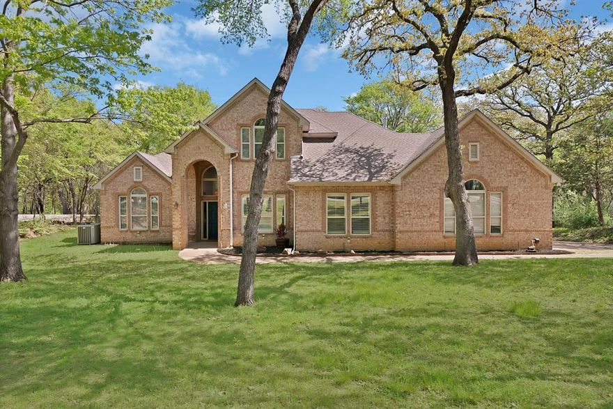 Exquisite 4-bedroom, 3-bathroom residence situated on approximately 1 acre in Oak Point, offering 2,868 square feet of thoughtfully designed living space. This home blends refined interior finishes with exceptional outdoor living.

The well-appointed floor plan features the primary suite and a secondary bedroom on the main level, with additional bedrooms upstairs for added privacy. Interior highlights include hardwood flooring, travertine tile, and spacious living areas designed for both comfort and functionality.

The primary suite serves as a private retreat, complete with dual vanities, a jetted tub, separate shower, and a generous walk-in closet. Open-concept living and dining spaces create a seamless flow, ideal for entertaining.

The outdoor setting is designed for elevated living, featuring a resort-style pool and a fully equipped outdoor kitchen, perfect for hosting and enjoying the surrounding natural landscape. The property backs to Corps of Engineers land near Lake Lewisville, providing enhanced privacy and scenic views.

Additional features include a 4-car garage and a detached workshop or additional storage space, offering versatility for a variety of needs.

A rare opportunity to enjoy luxury, space, and privacy with convenient access to nearby amenities, dining, and major thoroughfares.