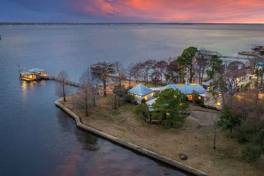 The legendary and renowned architect Frank Welch, is epitomized in this stunning modern lake house, a true testament to Texas modernism. This residence showcases many of Welch's signature trademarks, including vaulted ceilings, expansive glass, and strategically placed skylights that flood the home with natural light while framing breathtaking views on .81 acres and 310' of shoreline PER SURVEY.

Welch's designs has earned the most prestigious Medal of Art Award, reflecting his significant contributions to architecture. A protégé of the esteemed O’Neill Ford, Welch attracted clients from affluent backgrounds, including the notable Bass family, who sought his uniquely unpretentious yet exquisitely detailed modernist homes crafted from stone, glass, and wood.

As you step into this residence, you are immediately captivated by its architectural brilliance. The foyer welcomes you with a stunning wall of windows that offers a panoramic view of Cedar Creek Lake. The open floor plan emphasizes the home's connection to its natural surroundings, allowing for picturesque sunsets and water views from nearly every room.

A striking feature of the living area is the stone wood-burning fireplace, a remarkable centerpiece that soars to 13.5 feet, bridging the dining and living areas with an inviting warmth. Whether cooking, dining, or entertaining, the floor to ceiling windows from all these areas, draws the eye toward the serene lake. 

Off the primary suite, a solarium invites you in the beauty of the outdoors, where the lake becomes a constant companion to your everyday life. This Frank Welch-designed home is not just a residence; it is a legendary piece of architecture that harmonizes with its environment, embodying the essence of modern living in Texas.

NOTE: The fourth bedroom with spiral case leading to the loft above, does not have a dedicated closet. It offers concealed shelving with no rod for hanging. Easy conversion. This home currently sleeps 12 people