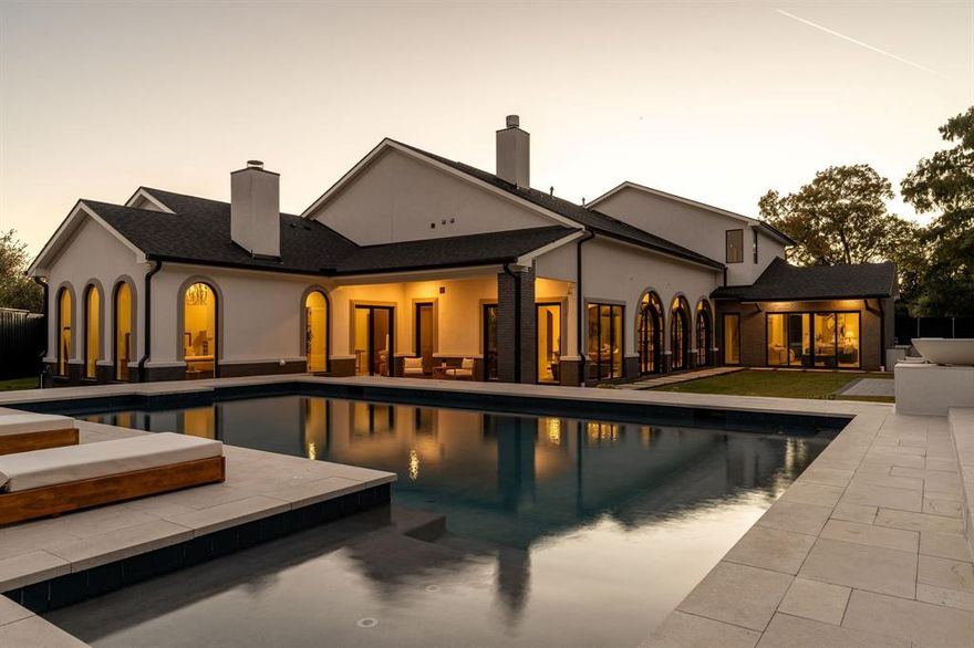 Experience modern elegance in the heart of Preston Hollow. This meticulously designed estate blends timeless style with everyday comfort, featuring four en-suite bedrooms, six baths, two stunning living areas, and dual full kitchens ideal for entertaining. The chef’s kitchen showcases Thermador appliances, a Hestan range, and a custom stone vent hood, complemented by a full secondary kitchen and butler’s pantry. Venetian plaster walls, soaring ceilings, designer lighting, and three statement fireplaces create a refined warmth throughout. Step outside to a resort-style backyard with a sparkling pool, fountains, outdoor kitchen, multiple lounge spaces, and a private sauna. Upstairs, over 1,000 square feet of flexible living space offers endless possibilities—media lounge, fitness studio, or guest retreat. Luxury, comfort, and design converge beautifully in this Preston Hollow masterpiece.