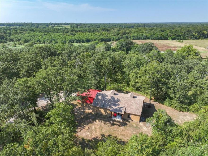 Secluded on 3 acres and surrounded by mature trees, this 3-bedroom, 2.5bath home offers the perfect blend of rustic charm and modern comfort. The open concept design features a vaulted living room ceiling with exposed beam, granite countertops, custom cabinetry, and a spacious kitchen island with seating. Relax on the front porch and take in the peace, nature, and abundant wildlife that make this property feel like a private retreat. A covered carport adds convenience, while the wooded setting provides seclusion. An added opportunity awaits with the neighboring property also available for purchase. 100 acres with a 2,500 sq. ft. home and established trails connecting the two. Together, they create a rare chance to expand your homestead, recreational space, or investment.  See MLS 21049098