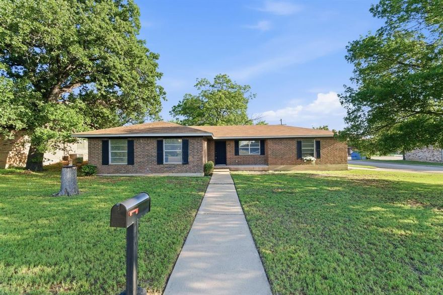 Welcome home to this beautifully updated 3-bedroom, 2-bath home,ideally situated on a
spacious corner lot in Cisco, Texas. Offering approximately 2,064 square feet of well-designed
living space, this home blends comfort, functionality, and a polished, move-in ready feel in a highly
convenient location. Remodeled around 2019 with a new roof installed during that time, the interior features durable
 hard surface flooring, neutral finishes, and a comfortable, inviting layout. The main living
area is anchored by a painted brick fireplace, creating a warm focal point for everyday living and entertaining. The kitchen has been thoughtfully updated with granite countertops, a classic subway tile backsplash, stainless steel appliances, and ample cabinetry—designed for both style and everyday ease. Bathrooms have been updated with granite countertops, continuing the cohesive, clean design throughout the home. Toward the back of the home, a flex space flooded with natural light can be utilized as a playroom,
office space, additional living area, or whatever best fits your lifestyle. Outside, you’ll find a 2-car attached garage along with a detached garage or workshop, providing excellent flexibility for storage, hobbies, or workspace needs. Located across the street from the city park and Cisco Junior High and Cisco High School, this home offers everyday convenience in an established neighborhood.
