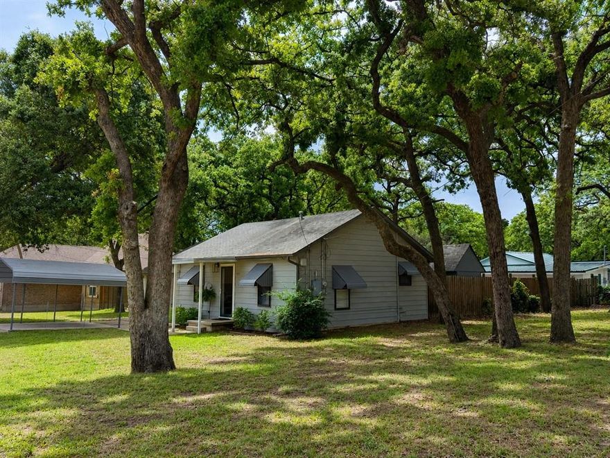 Welcome to this beautifully updated cottage-style home nestled on a spacious corner lot in the established Indian Oaks neighborhood near Lake Worth. Blending timeless charm with modern upgrades, this move-in ready home offers comfort, character, and functionality all in one. Inside, you’ll find original oak hardwood floors paired with new ceramic tile and luxury plank vinyl throughout. The flexible floorplan features 2 bedrooms, 2 full bathrooms, a cozy living area, dining room, dedicated laundry room, and an updated kitchen with abundant cabinet space. All appliances are included — washer, dryer, refrigerator, gas range, and dishwasher — making this home truly turnkey. Recent updates include central heat and air installed in January 2026, along with extensive interior improvements throughout the home. Outside, the oversized corner lot is shaded by mature oak trees and offers a private fenced backyard perfect for relaxing or entertaining. Additional features include a double carport, two large storage buildings, plus a workshop and hobby room providing exceptional storage and workspace without the need for off-site storage. Conveniently located near shopping, dining, Eagle Mountain Lake, and major highways, this property is ideal for first-time buyers, down-sizers, or anyone looking for a cozy home with modern updates and extra space to enjoy.