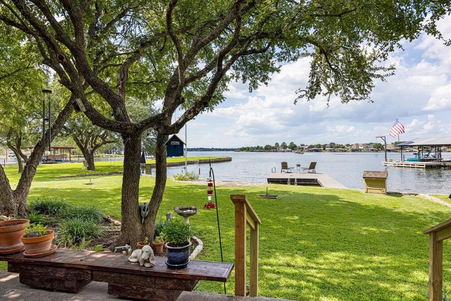 A rare find, walk-out water, on main body Lake Granbury, with deep water, a private swimming cove, spectacular views, awesome sunsets and a totally renovated lake house. This one has it all and is perfect for a vacation rental property. There is 79 feet of waterfront property to enjoy with a durable, long lasting, TREX fishing dock and a private community boat ramp. The newly renovated house has been expanded to 3581 square feet with 4 bedrooms (2 are master bedrooms and both located on the first floor), 3.5 baths plus a dedicated office. The kitchen, dining, guest lake suite and living areas all offer incredible views that are truly breathtaking! The versatile upstairs bedrooms are currently being used as a craft room and a man cave, but there are so many possibilities with the upstairs space and could be easily adapted to suit various needs. There is a model train room that could serve as an additional office or playroom. Outdoor living is gorgeous with mature pecan and oak trees, horseshoe pit and ample opportunities for fishing and swimming. The backyard is the perfect place to enjoy views of the lake, drink your coffee, entertain guests or watch the sun set with a glass of wine. This property could be your dream home on the lake, a weekend getaway or even a great short term rental investment. The guest lake suite is handicap accessible with a large closet and awesome lake view. The home offers abundant climate controlled storage, including a walk-in attic storage and a mini-split AC unit in the garage.  This property is nestled at the end of a quiet cul-de-sac. This is a truly exceptional property! Come take a look and dip your toes in the lake.