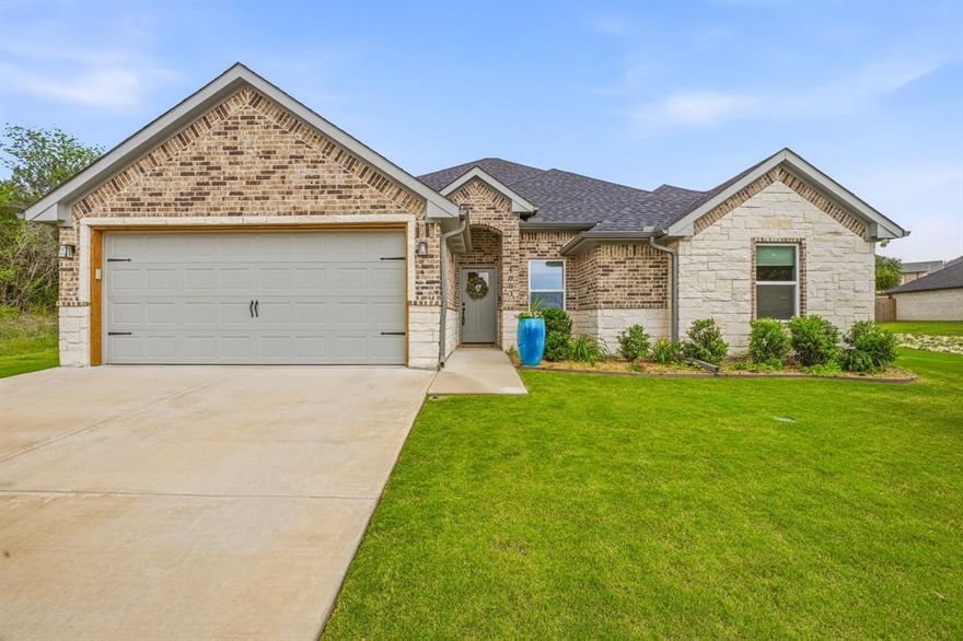 Experience the best of Granbury real estate in this rare 4-bedroom home located in the gated lake community of Canyon Creek. Located on a very spacious lot where you are not on top of your neighbors.  This beautiful property has a well established lawn with a full sprinkler system, in the front and backyard. While many homes in this neighborhood offer only three bedrooms, this spacious open-concept layout provides valuable flexibility for a home office, nursery, or hobby space—without the wait or added expense of new construction. This move-in ready, better-than-new home is designed for energy efficiency and modern living, featuring fully encapsulated spray foam insulation, energy-efficient windows, and a smart thermostat to help keep utility costs low during the Texas heat. Inside, you’ll find sleek tile flooring throughout—no carpet—and a bright, open layout ideal for both everyday living and entertaining. The kitchen offers granite countertops, stainless steel appliances including the refrigerator, and soft-close cabinetry for a clean, upgraded feel. The private primary suite serves as a relaxing retreat with dual vanities, a large walk-in shower with designer tile, and the rare bonus of two separate walk-in closets. Additional features include a whole-home surge protector and transferable builder warranty for added peace of mind. Outside, enjoy an established yard on an oversized lot with enhanced privacy and a peaceful setting near a seasonal creek. The covered back patio is perfect for outdoor living, and a 10x16 storage shed on a slab provides excellent extra storage. Canyon Creek residents enjoy gated security, two swimming pools, pickleball and basketball courts, a playground, and lake access with a private marina on Lake Granbury. Conveniently located near shopping, dining, and the historic Granbury Square within highly sought-after Granbury ISD, this home offers the ideal combination of space, efficiency, and lifestyle. Welcome Home!
