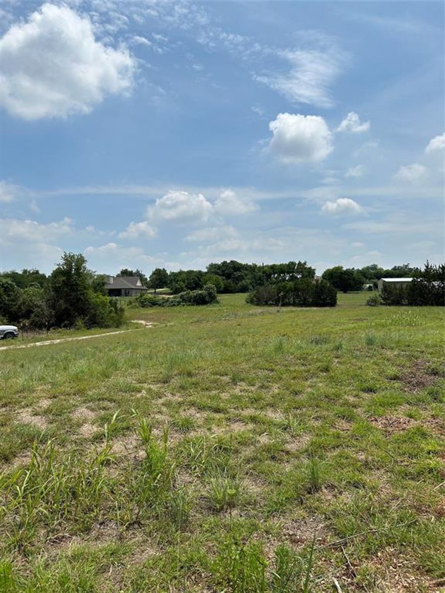 Many options with this 6.1 acre lot.  Motivated Seller!  Open spaces as well as treed fence lines.   Great spot to build your dream home, secluded from the city, but close to schools and shopping,   NO HOA and your can build a barnominium.   Horses, cattle and small farm animals allowed.   Development restrictions are in the MLS documents to protect your investment, yet relaxed enough to give you freedom on your own land.   Gravel road has been added along with a water well and two electrical meters.   There is no septic on the property yet.  Property is semi fenced and sets back off the main road.  Great property for building or just enjoying the outdoors.  One of few lots in this area that can have two residences built on it.   RV will be removed and all personal items removed at time of closing.   Shed is negotiable.  RV and Shed are on gravel pads.  You need to walk the property to see it's full beauty and potential.  No mobile homes allowed.