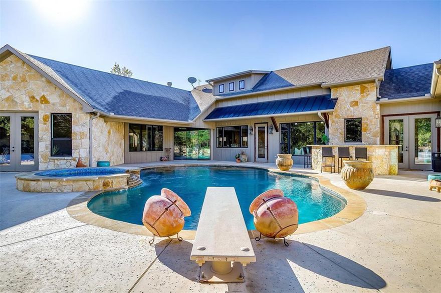 $300K+ in equity already! This property was appraised just a couple of months ago for a little over $2.2M! Use that extra equity for a interest rate buy down or towards closing! Do you want it all but want to live in the peace and quiet? YOU GET IT WITH THIS ONE! Already AG exempt, 4Bedrooms, 3Baths,2.5Garage, plus large shop that would hold approx. 4 more automobiles. Entertainers Dream with a dive pool, hot tub, gas fire pit, full outdoor kitchen and guest quarters. All of this can be seen from every room facing the outdoor excitement as it has windows galore! The kitchen is equipped with professional grade built in refrigerator, gas range, ice maker and copper sinks.  Ensuite offers a his and hers closet. The guest quarter has its own kitchen and full bathroom.  Shop has central heat and AC with washer and dryer hookups.   There are no words to describe how amazing this private oasis is, you must see it to believe it! There are ton of deer, turkey and all other kinds of wildlife!