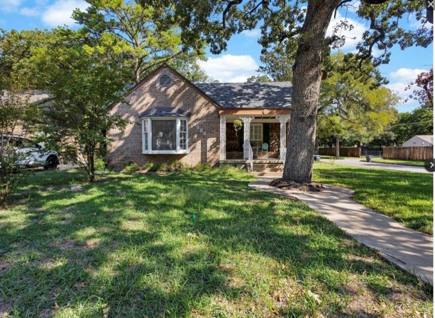 Nestled in the picturesque Oakhurst neighborhood, known for its tree-lined streets and welcoming community, this beautifully updated three-bedroom, two-bath home blends classic charm with modern comfort. As you step inside, you're greeted by refinished original hardwood floors and a fresh, neutral paint palette that flows throughout the main living areas. The inviting front living room features a large bay window—perfect for watching the neighbors go by—and a stunning brick fireplace that spans the entire wall, creating a cozy focal point. Stylish modern light fixtures elevate both the living and dining rooms, while the galley-style kitchen offers efficient use of space for everyday living. Just beyond the kitchen, you'll find an oversized bonus room—ideal for a second living area, game room, playroom, or home office. The spacious primary suite boasts a completely renovated en suite bath, designed with a spa-like touch in calming blue tones. It features a large walk-in shower, modern soaking tub, and double vanity—perfect for relaxing and recharging. Storage is plentiful, with several large closets throughout and not one, but two two-car garages offering flexible options for parking, storage, or a workshop. Sellers have updated electric, new water heater, complete primary bathroom renovation, lighting, paint, flooring, hardwired security cameras. NEW ROOF IN AUGUST OF 2025