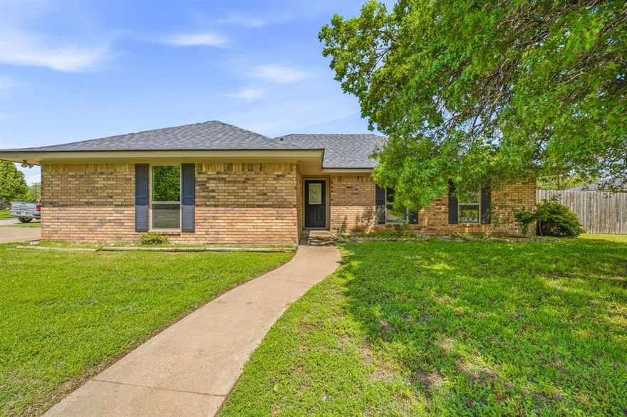 Welcome to a home where everything is brand new, without the stress, time, or cost of doing it yourself. This fully renovated 3-bedroom, 2-bath brick home sits proudly on a spacious corner lot and offers the perfect combination of quality craftsmanship, modern finishes, and true move-in-ready convenience. From the moment you pull up, you’ll notice the standout curb appeal with its classic brick exterior and charming rock mailbox. Step inside to a warm and inviting living room centered around a beautiful brick fireplace, creating the perfect space to relax or gather with family and friends. The home flows seamlessly into a bright, open kitchen filled with natural light. Featuring stunning quartz countertops, abundant cabinetry, and a clean, modern design, this kitchen is as functional as it is eye-catching. Throughout the home, you’ll find completely redone hardwood floors that bring a cohesive, high-end feel to every room. The primary suite is generously sized and enhanced by elevated ceilings, giving it an airy, luxurious atmosphere. The en-suite bathroom has been fully updated with a double vanity and a large tiled walk-in shower designed for both comfort and style. The guest bathroom is equally impressive, featuring an insulated tub for added efficiency and comfort, along with a seamless quartz shower that elevates the space with a sleek, modern finish. Step outside to a large, fully fenced backyard…perfect for entertaining, pets, or simply enjoying your own private outdoor space. The covered back patio with a concrete slab makes outdoor living easy year-round. Additional highlights include a 2 car garage and a brand new roof, adding even more value and peace of mind. This home truly offers all the new without the weight…no repairs, no updates, no to-do list. Just move in and enjoy a fresh start in a beautifully finished space.
