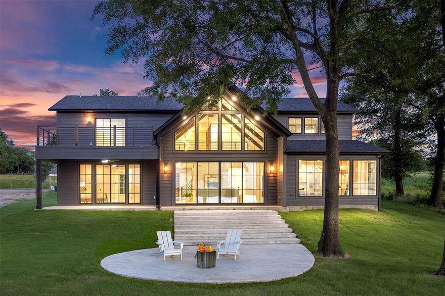 UP TO 3% IN SELLER CONCESSIONS WHEN USING OUR PREFERRED LENDER. CAN SLEEP 12+. This modern farmhouse mini mansion on the water is truly a remarkable find, set on over half an acre with breathtaking waterfront views. When you step inside, you’re immediately captivated by a wall of windows that frame stunning views of the lake. The home boasts engineered hardwood floors throughout, quartz countertops, and beautifully tiled bathrooms. The heart of this home is the kitchen, designed for both chef enthusiasts and casual cooks alike. It features plenty of space to move around, custom cabinets that include lit display cases at the top. Gorgeous bubble chandeliers hang gracefully over the spacious kitchen island and the dining table. A wall of windows off the dining area allows for uninterrupted lake views. The cutting-edge appliance package includes black stainless steel by Z Line, with a standout oven from the luxury brand Thor, known for its association with Gordon Ramsay. This oven has all the bells and whistles, making it a dream for any culinary enthusiast. The open floor plan seamlessly integrates these areas. The primary suite is conveniently located on the first floor, featuring a luxurious bathroom that has a grand wet room, reminiscent of upscale residences. As you ascend the staircase, adorned with a grand chandelier, you’ll find an overlook that provides a stunning view of the great room with up to 17' ceilings. The second floor offers a fantastic space for guests or family members, complete with a game room and TV area.   A large concrete pad invites gatherings around a fire pit, creating a perfect spot for entertaining friends and family. This gated community also provides private amenities, including an infinity-edge swimming pool, boat ramp, and a gym, making this home an ideal location for a luxurious lifestyle filled with recreation and relaxation. This home, built by Coastal Plains Custom Estates, showcases the most trendy styles, finishes.