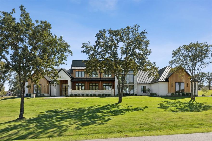 Experience refined living in the gated community of Santana Ridge Estates, located within the highly regarded Brock ISD. This exquisite 4-bedroom, 4 and a half bath home on a 2-acre lot blends modern elegance with country charm. A welcoming front courtyard porch leads into an open-concept floor plan centered around a double-sided fireplace and hand-scraped white oak hardwood flooring throughout. The gourmet kitchen features Taj Mahal and quartz countertops and a hidden catering kitchen, perfect for entertaining or meal prep. Extend your gatherings outdoors with a covered back porch and full outdoor kitchen. Each bedroom includes a private ensuite and walk in closet, offering comfort and privacy. The primary ensuite features a luxurious steam shower and designer finishes. A floating staircase with white oak threads ascends to the spacious game room and dedicated study. Throughout the home, you’ll find porcelain and natural stone tile in wet areas for both beauty and durability. Smart home conveniences include a Josh Ai panel, integrated Lutron power shades, built-in speakers, and security cameras. A 4 car epoxied garage completes this thoughtfully designed residence. This property captures the perfect balance of modern luxury and relaxed country living in one of Brock’s premier gated communities.