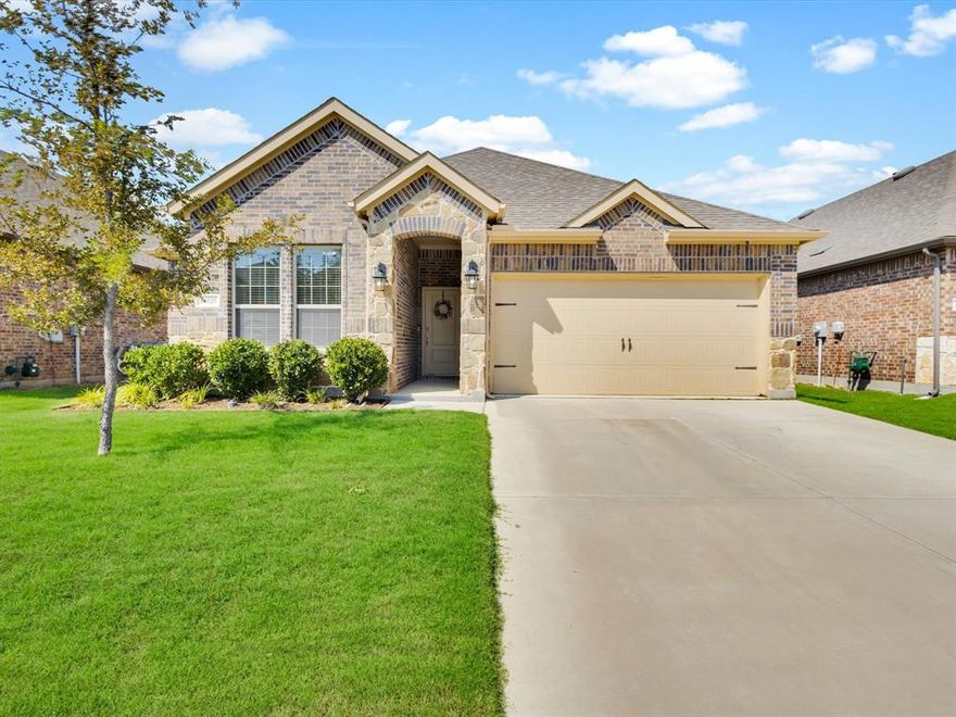 Built in 2021, this 3-bedroom, 2-bathroom home is filled with thoughtful upgrades in the sought-after Silverado community of Aubrey. Step inside to an open floor plan where wood-look tile floors flow through the main living areas, anchored by a cozy gas-starter fireplace with gas logs and a glass front. The designer kitchen features quartz countertops, a hexagon tile backsplash, Whirlpool stainless steel appliances including a 5-burner gas range and an oversized island with bar seating. A walk-in pantry and adjacent dining area make it ideal for everyday living and entertaining. The private primary suite includes dual sinks, a soaking tub and a separate walk-in shower. Two additional bedrooms share a full bath upgraded with a tile-surround shower. Convenience is built in with a tankless water heater, integral blinds in the back door glass, a spacious laundry room with cabinet storage and dry area and a coat closet for extra storage. Out back, relax on the covered patio overlooking an oversized, private backyard. Enjoy all that Silverado has to offer, including a clubhouse, resort-style pool with splash pad, playgrounds, basketball and pickleball courts, dog park, walking trails and community ponds. This move-in ready home blends modern style with community living, just minutes from shopping, dining and Highway 380.