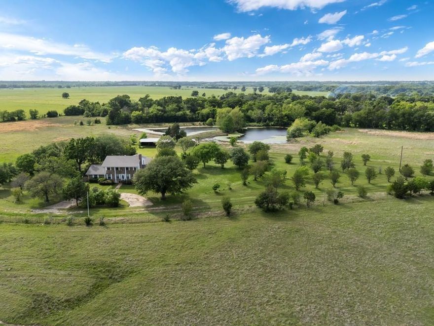 Elegant Colonial-style residence with a stunning crepe myrtle-lined driveway, set back from the road on a sprawling 29-acre estate. This property features a mix of wooded areas and open pasture, complete with a barn and ponds, offering ample space for living, working, and recreation. The two-story home, built in 1979, presents a unique opportunity for renovation, boasting solid construction and expansive square footage at an attractive price. The residence includes a brand-new roof and showcases the distinctive style of its era. With a little vision and effort, this could become your dream home. Inside, the property offers 4 bedrooms and 3 bathrooms, along with multiple living areas to accommodate various lifestyles. The interior features warm ash paneling and a fireplace with an insert, while the formal dining room, equipped with built-ins, is ideal for gatherings. The L-shaped kitchen is designed for efficiency, featuring butcher block counters, a pantry, and ample storage space. The spacious primary suite includes a walk-in closet, a separate shower, and a makeup vanity. Down the hallway, three large bedrooms and a generous hall bathroom provide additional comfort. A sunroom, office, and laundry room with built-ins add functionality and charm. Upstairs, a landing area offers potential for a library, a large game room, or a fifth bedroom, complete with a bath featuring a footed tub. An attached one-car garage provides convenience. While the home requires updating, this has been factored into the pricing. Outdoors, the property offers endless possibilities. A three-stall pole barn is ready for livestock or equipment, while two ponds and expansive open land provide space for cattle, horses, or recreational activities.