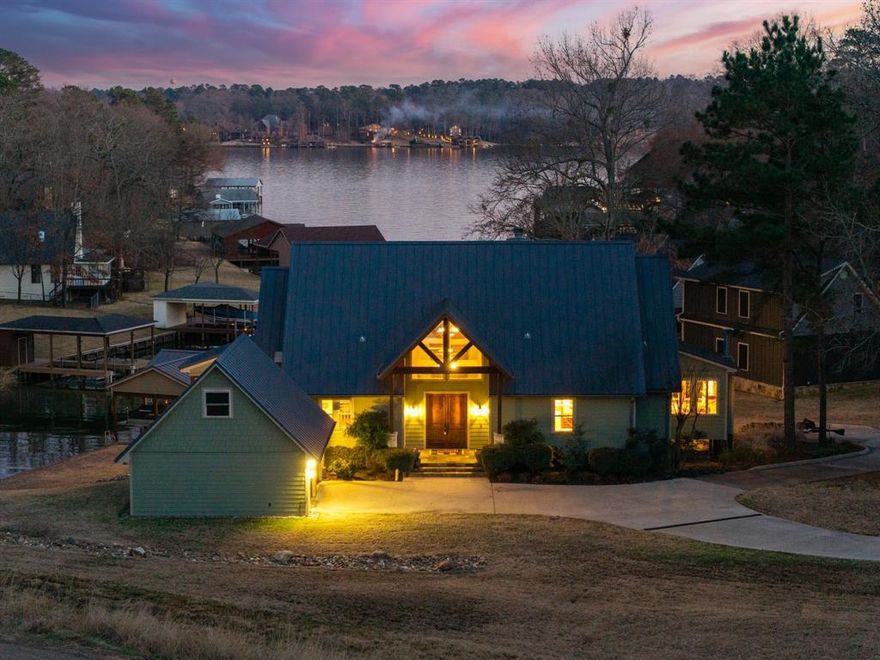 What a rare and unique opportunity on Cypress Springs! Located in the highly sought-after Kings Country, this exceptional waterfront home sits on an oversized double lot and offers fee simple ownership, not leasehold, a true rarity on the lake. Perfectly positioned in a protected cove with expansive main lake views, this property provides the ideal combo of open water scenery and calm conditions for swimming, paddle boarding, and protecting your over water investments. Thoughtfully designed with high-end finishes throughout, the home welcomes you with a stunning main living area featuring a wall of windows overlooking the lake and a beautiful stone fireplace as the focal point. The open kitchen flows seamlessly into the living space and includes granite counters, gas cooktop, double ovens, and a convenient butler’s pantry area. Just off the dining space, a covered patio spans the entire width of the home, creating the perfect setting for lakeside entertaining. The primary suite is truly a retreat, offering a luxurious ensuite bath, private sitting area with fireplace, and walls of windows capturing peaceful lake views. Downstairs you’ll find a spacious second living area with kitchenette, a second laundry room, and three guest bedrooms, two with ensuite baths. The lower level opens to another private covered patio, extending the home’s outdoor living options.Outside, the property truly shines with multiple covered patios, a screened outdoor space, and a beautifully designed two-slip boathouse. A detached two-car garage is a major bonus, as garages are a rarity on the lake, and the circular concrete drive provides abundant parking for guests. Kings Country residents enjoy gated entry, a sports court, boat ramp, interior lakes, and more. Even better, this home is being offered mostly furnished, making it ready to enjoy from day one. Newer boathouse and wall. Great Landscaping. Automated lighting and waterline leak detection- This home is truly a must see!