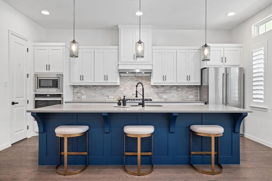 In a sea of builder-grade white, here’s your chance to move right into a home that still feels new—but with designer finishes and smart upgrades already in place.

From the inviting front porch to the airy, open living spaces, this home strikes the rare balance between polished and livable. Rich engineered hardwoods run throughout the main level, paired with modern, cohesive paint tones and upgraded lighting that instantly elevate the space. Just off the main living area, a built-in office nook is perfectly positioned for work-from-home days or homework drop-offs.

The kitchen is both beautiful and functional, featuring light quartz countertops, a built-in gas range with exterior-vented hood, under-cabinet lighting, and a walk-in pantry that actually lives up to the name. Nearby, a custom mudroom built-in keeps backpacks and daily clutter in check, while the laundry room adds cabinetry, shelving, and a utility sink for real-world convenience.
The primary suite is tucked away on the main level, offering generous space and a calm retreat feel. Upstairs, the layout continues to impress with a large gameroom and secondary bedrooms enhanced by upgraded flooring in place of builder carpet. Plantation shutters throughout the home add a finished, tailored look you simply don’t find at this stage of ownership.

Step outside and you’ll see where this home truly separates itself. The extended patio and covered pergola create a full outdoor living space, complete with built-in grill, refrigerator, storage, and room for a smoker—ready for game days, weekend dinners, and casual entertaining. Thoughtful privacy upgrades, fresh landscaping, and plenty of grassy yard space round out the backyard experience.

All of this is set within a highly desirable community offering multiple pools, parks, trails, and a clubhouse with fitness center—delivering both style and lifestyle in one move-in-ready package.