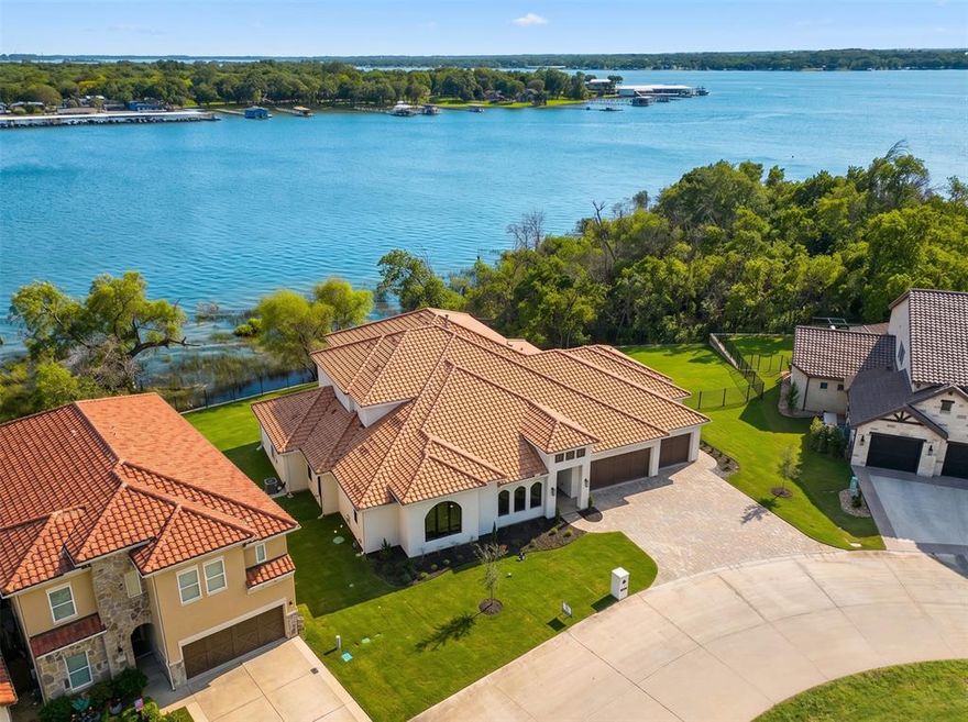 Experience resort style living at its finest in this exquisite custom home nestled on the shores of Eagle Mountain Lake. Boasting 4 spacious bedrooms, 4 full and 2 half designer bathrooms, and a 3-car garage, this home offers an ideal blend of elegance, comfort, and functionality.

Step into an expansive open-concept great room, kitchen, and dining area, perfectly designed for entertaining. The chef-inspired kitchen features an upgraded appliance package including a 48” 6-burner gas cooktop, double wall ovens, and a built-in refrigerator. Custom cabinetry throughout the home is enhanced by soft-close drawers, adding both style and convenience.

The white oak wood flooring flows seamlessly through living spaces and into the luxurious primary suite. Step outside to a massive covered patio overlooking breathtaking water views—an ideal space for relaxing or hosting guests.

Upstairs, enjoy a spacious game room with access to an upper-level balcony that offers lake views..

With too many high-end features to list, this home is truly a must-see. Schedule your private tour today and discover the ultimate in luxury lake living.