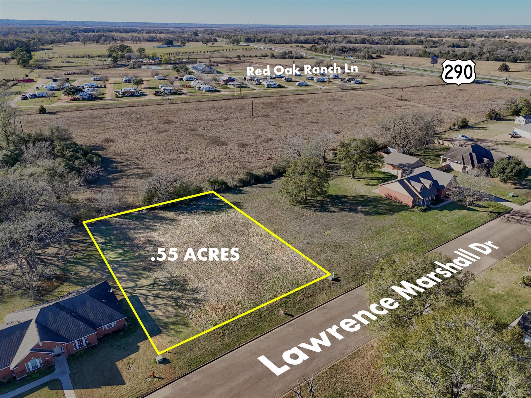 Aerial view highlighting the approximately 0.55-acre residential lot with frontage along Lawrence Marshall Drive, showing approximate boundaries, surrounding homes, and convenient proximity to Hwy 290.