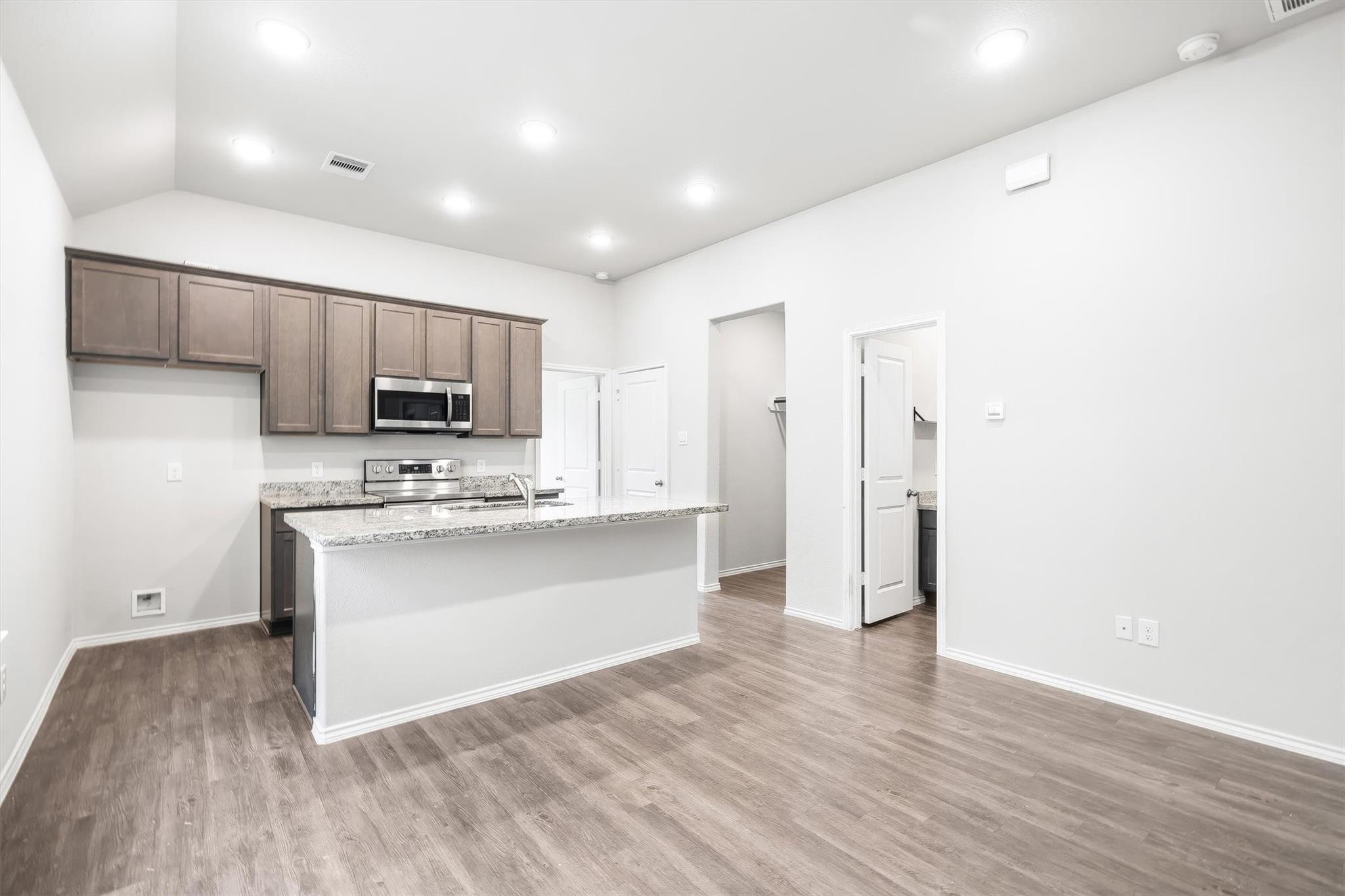 This view from the entry shows you exactly how the floorplan flows ? the living space is open and generous, the kitchen sits right at the heart of the home, and the hallway beyond leads directly to the bedrooms, bathroom, and laundry area. Everything is connected and easy to navigate, which is one of the things that makes this layout live so well.