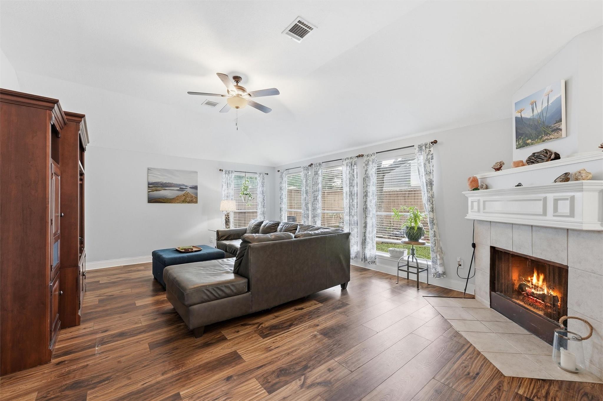 Living room features a cozy fireplace, abundant natural light, and seamless access to the kitchen and breakfast area.