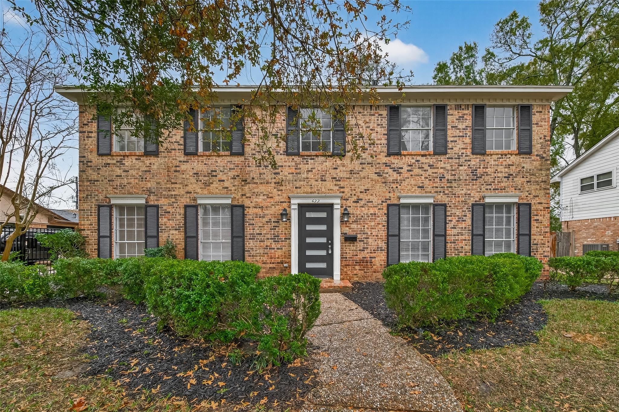 Welcome Home, to this charming and well maintained two-story brick home with a classic exterior, large windows, and black shutters.