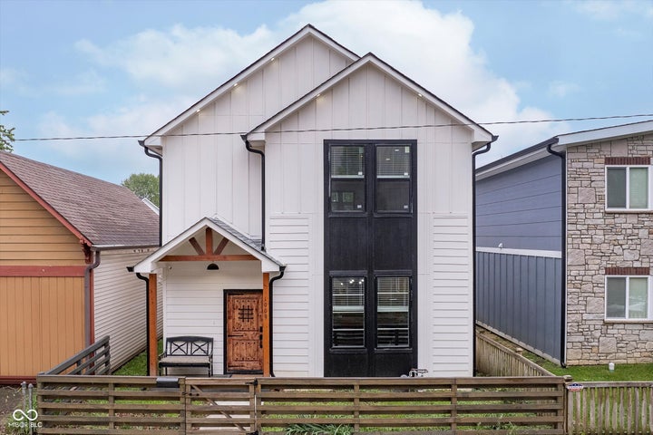 view of front of home with a fenced front yard, stone siding, and board and batten siding