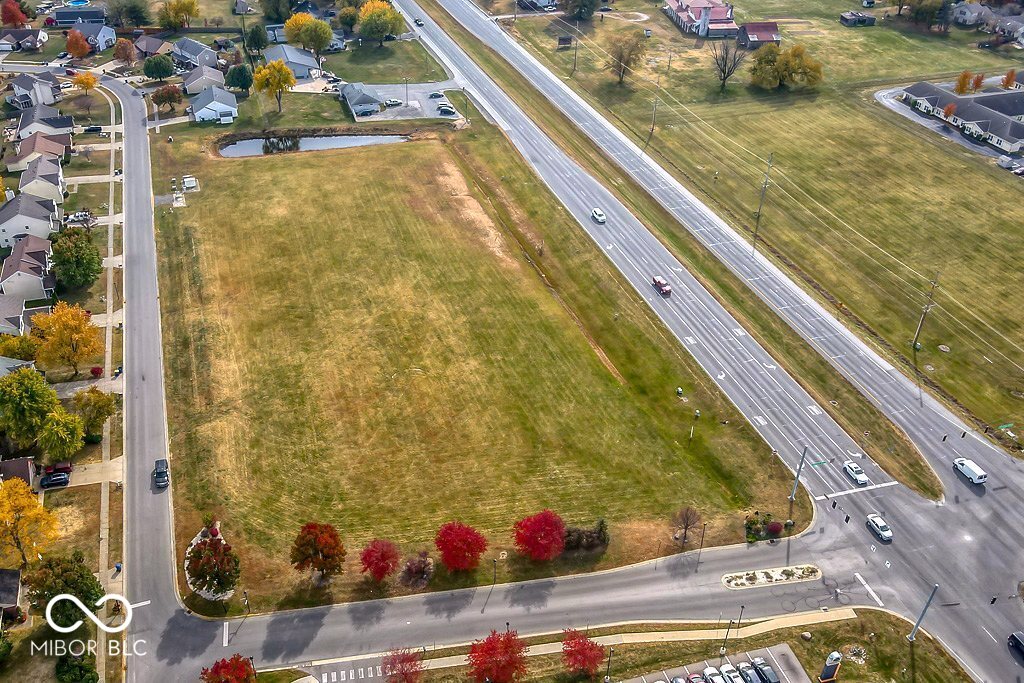 aerial view of property and surrounding area with a major roadway and nearby suburban area