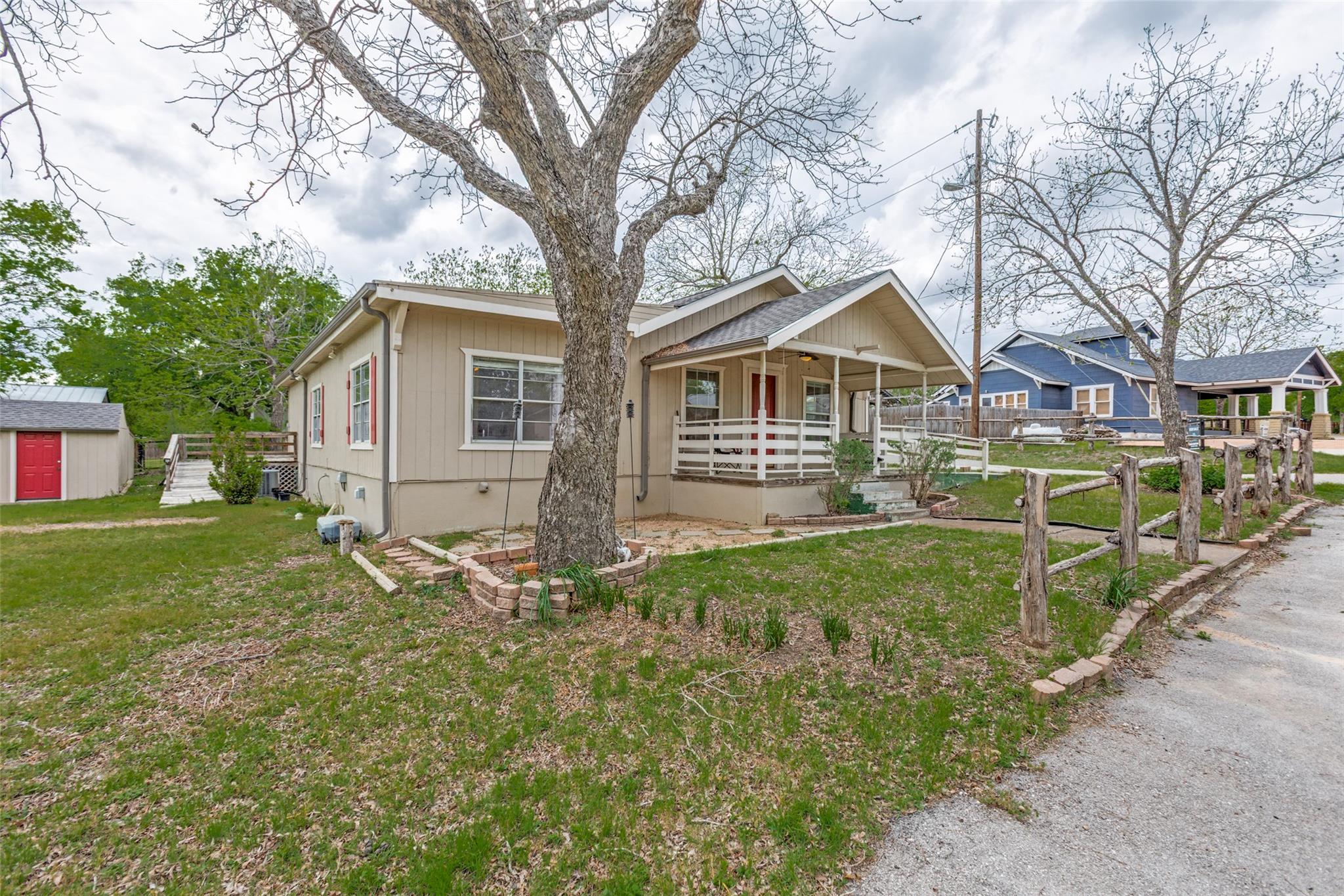 Bungalow featuring a porch and a storage unit