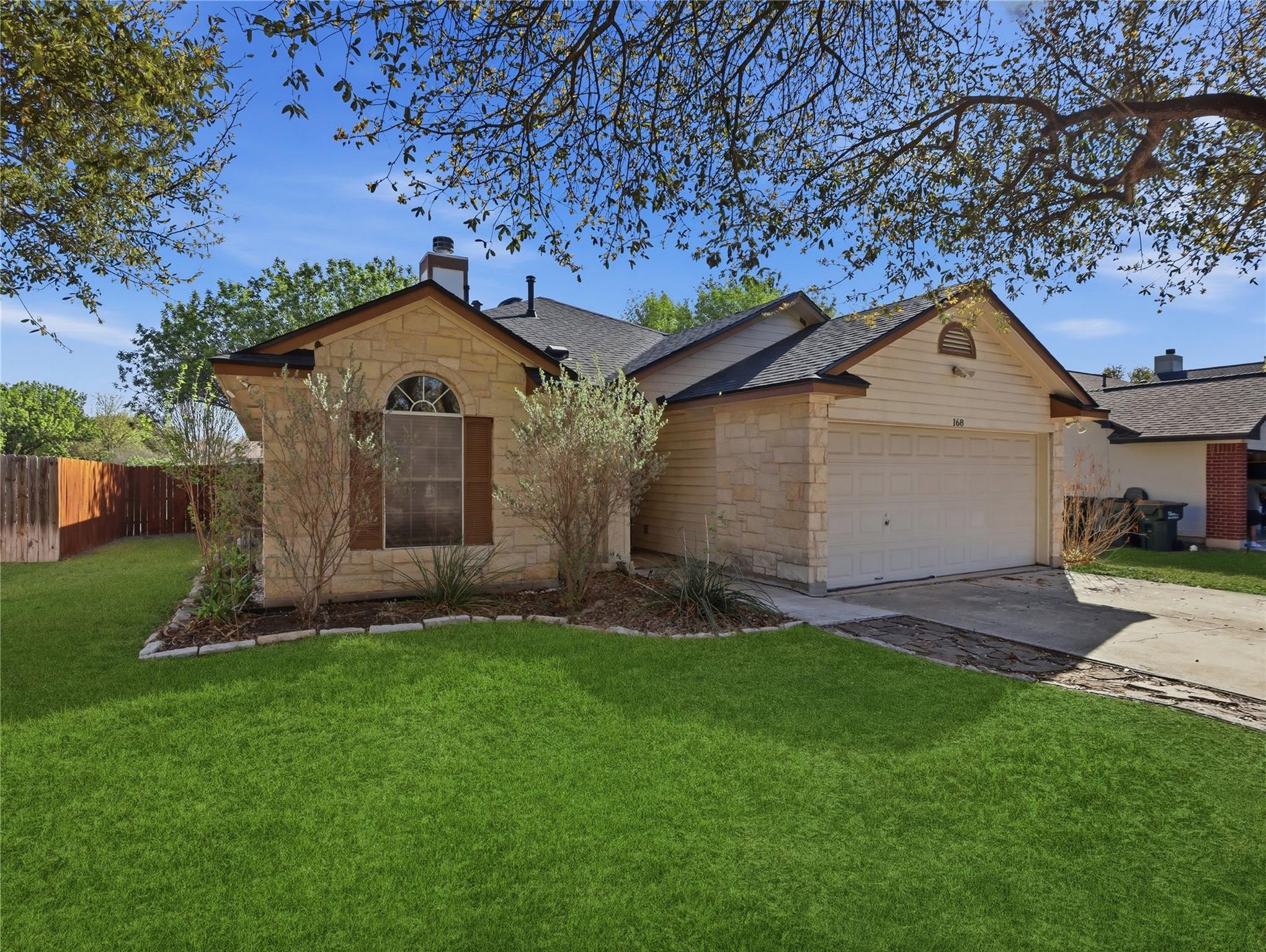 Single story home with stone siding, concrete dri