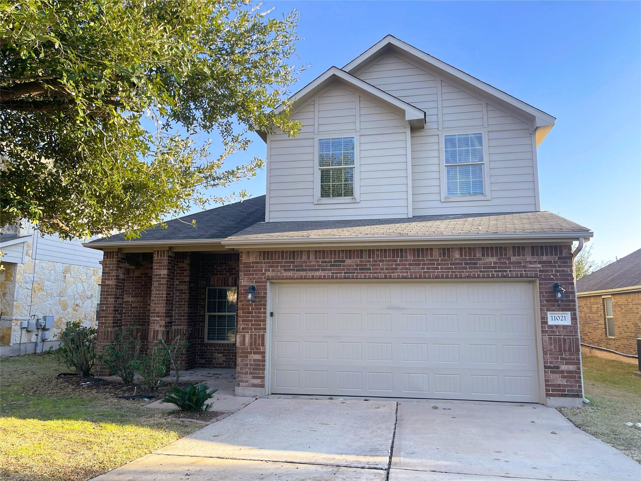 Traditional home featuring brick siding, concrete