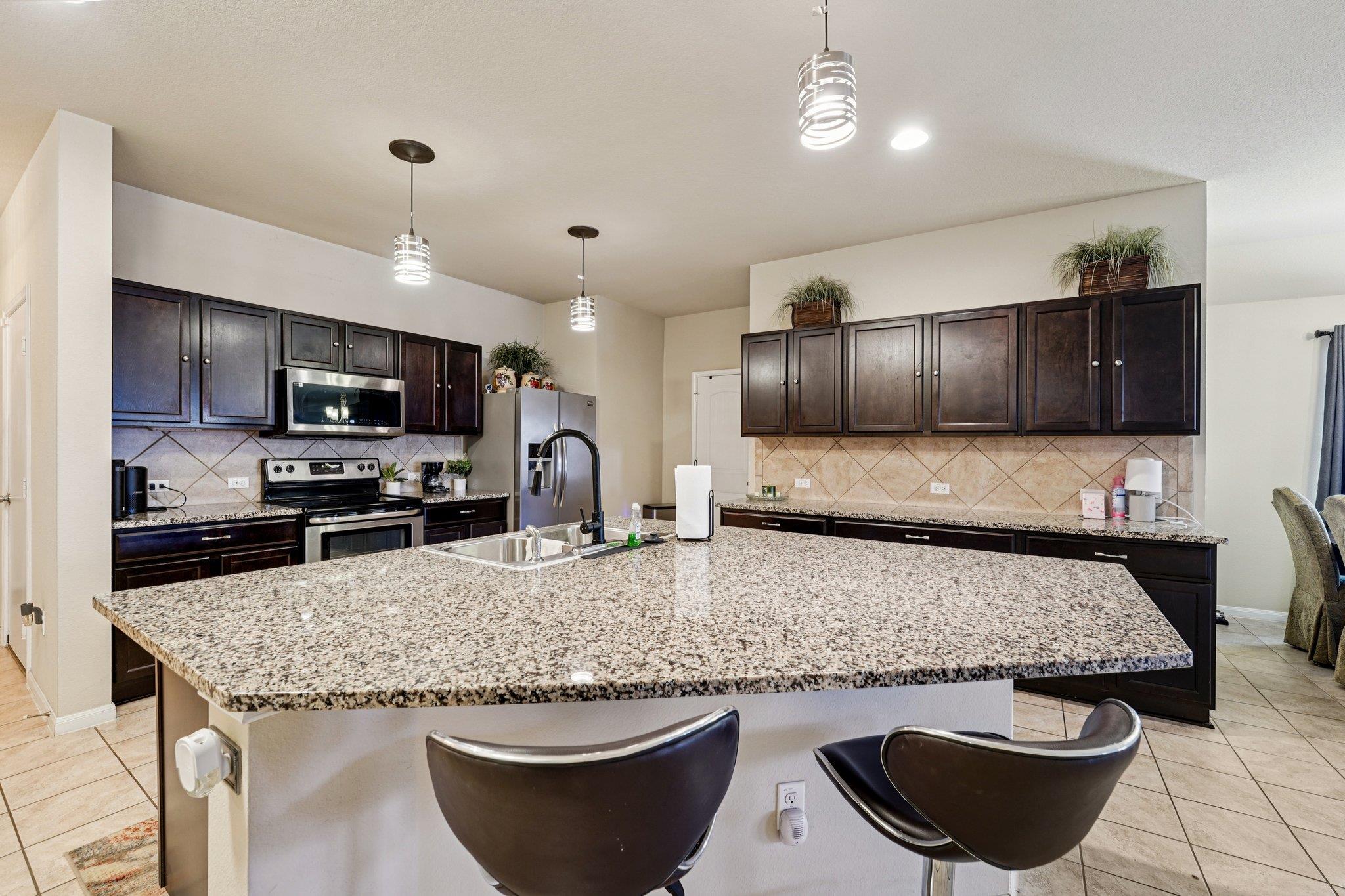Kitchen with light stone countertops, stainless s