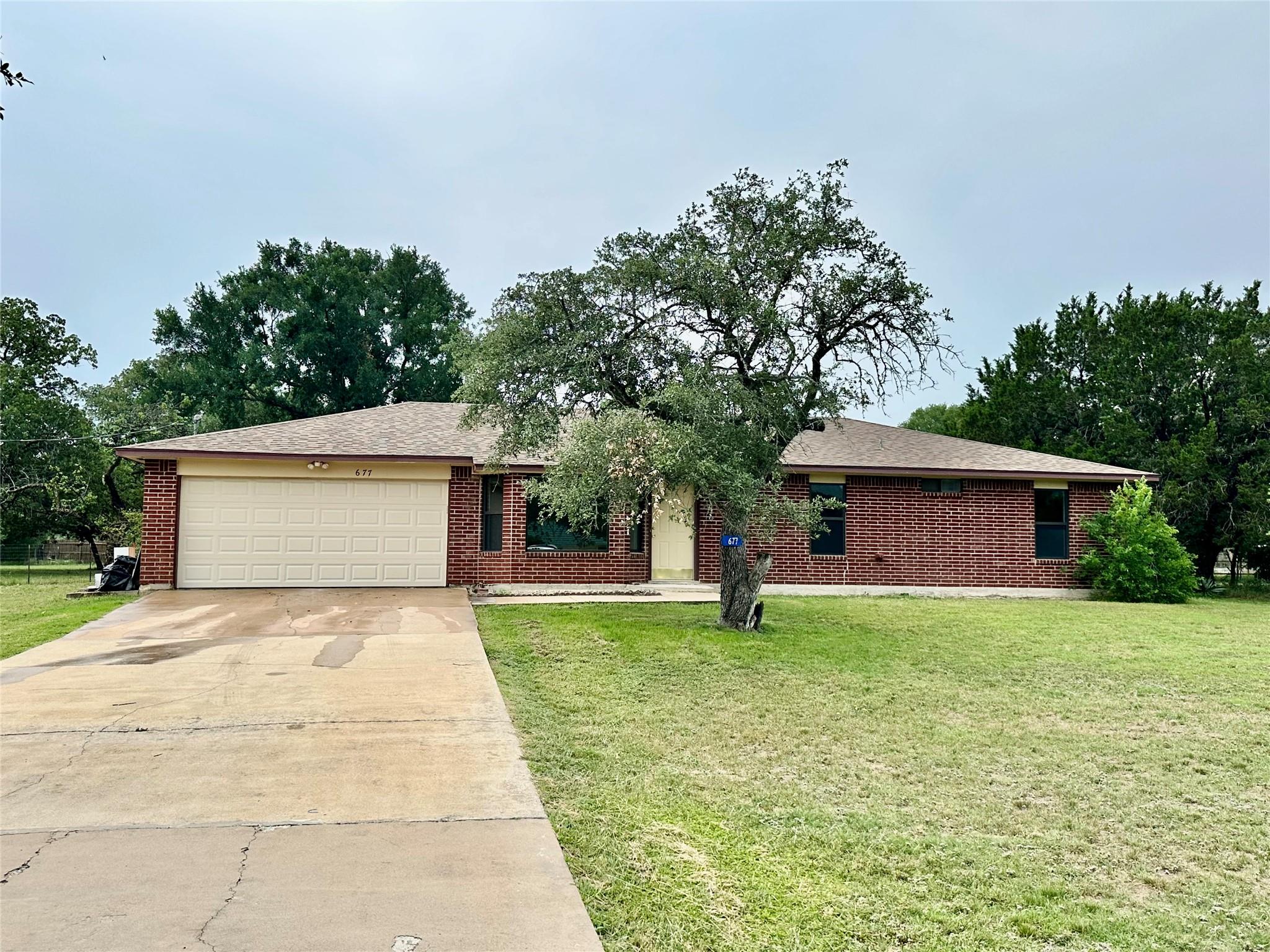 Ranch-style home featuring a garage, driveway, an