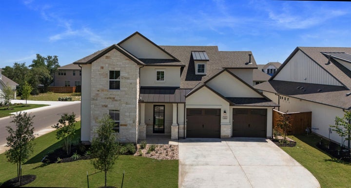 Property under construction featuring driveway, a garage, and stucco siding
