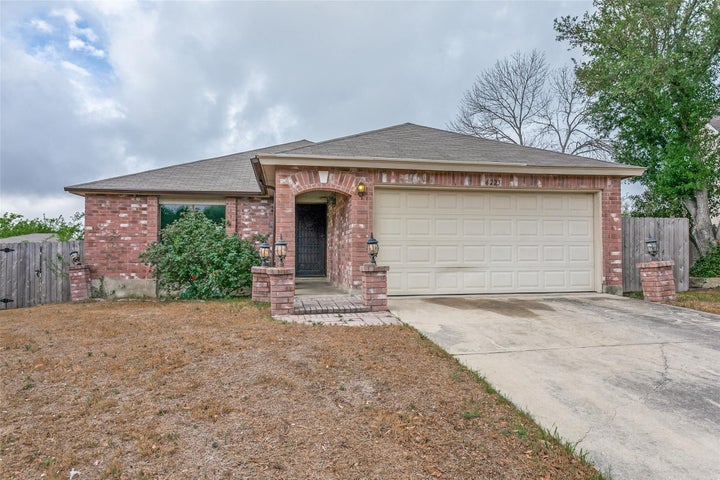 Ranch-style house featuring roof with shingles, brick siding, concrete driveway, and a garage