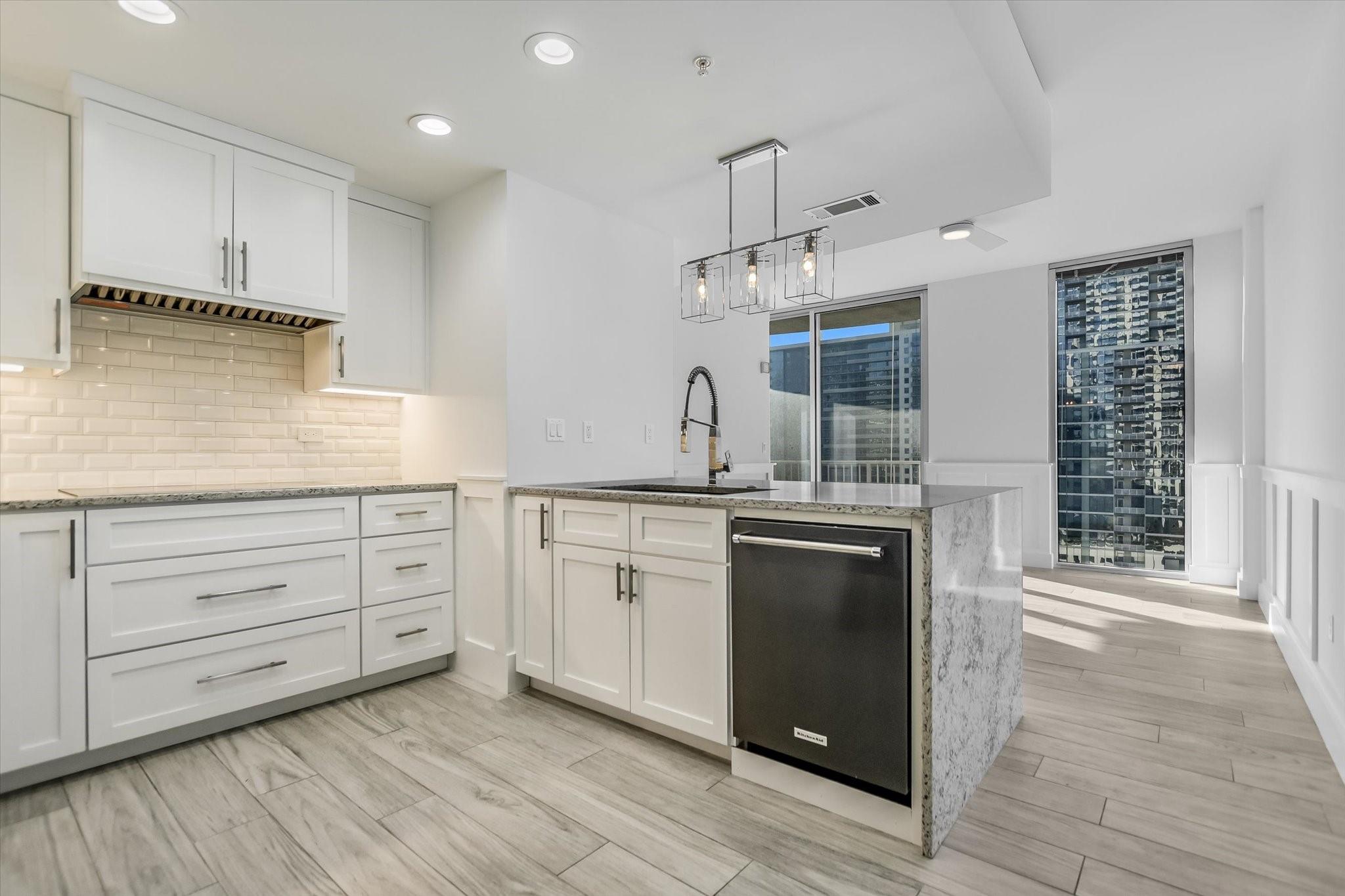 Kitchen featuring sink, kitchen peninsula, and white cabinets