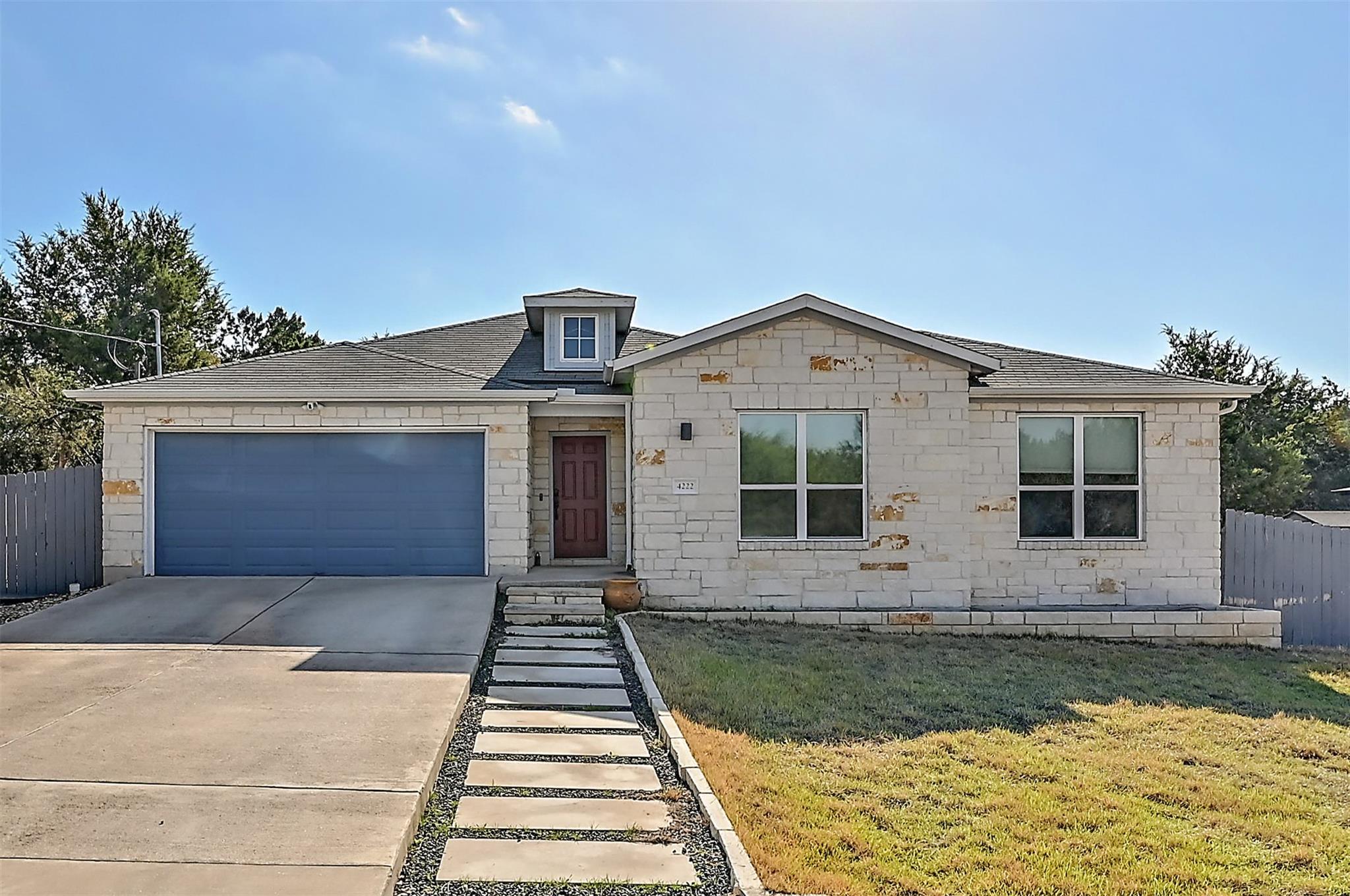 View of front facade featuring fence, roof with shingles, concrete driveway, a front lawn, and a garage