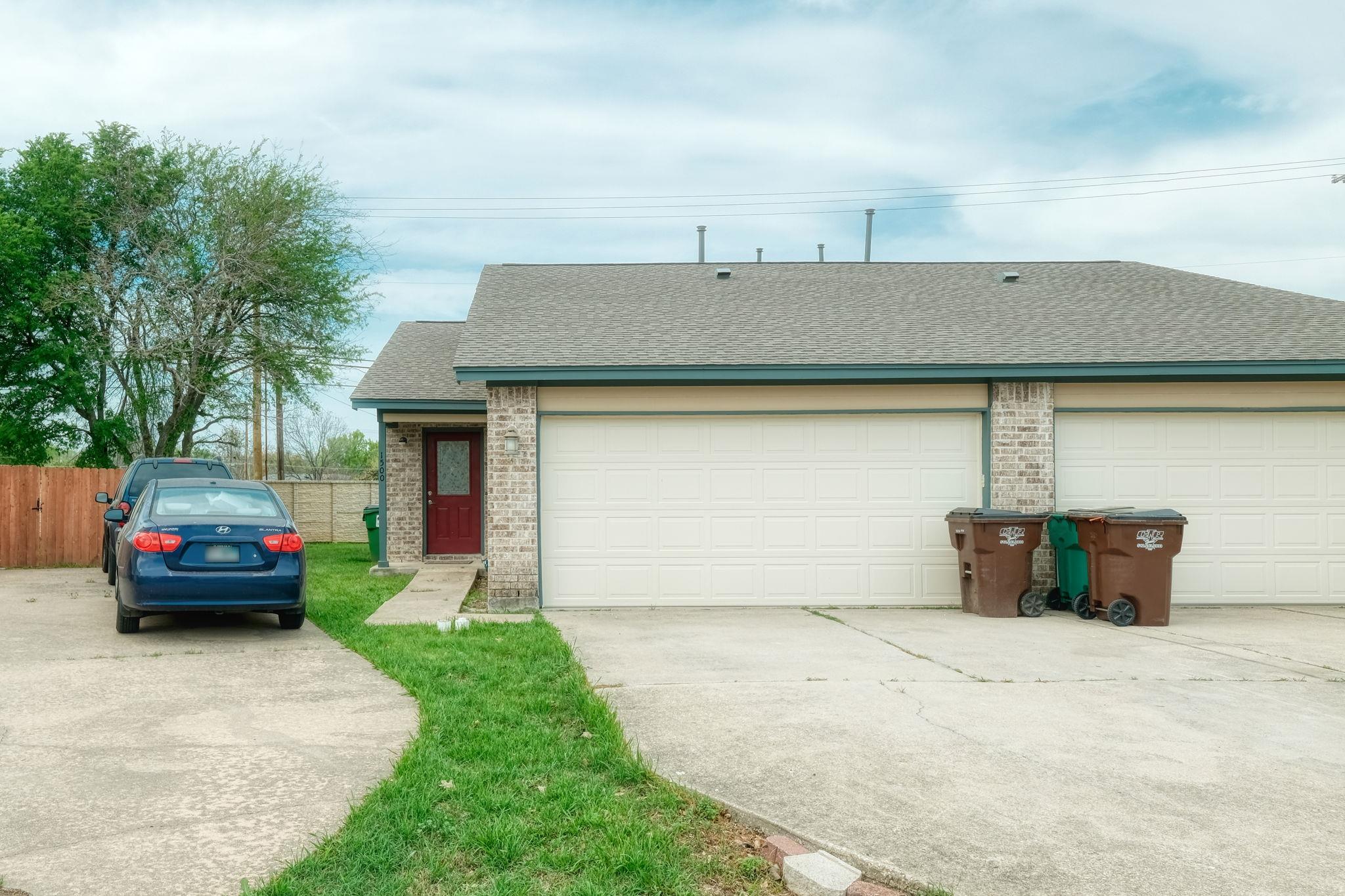 Brick exterior featuring a two-car garage with se