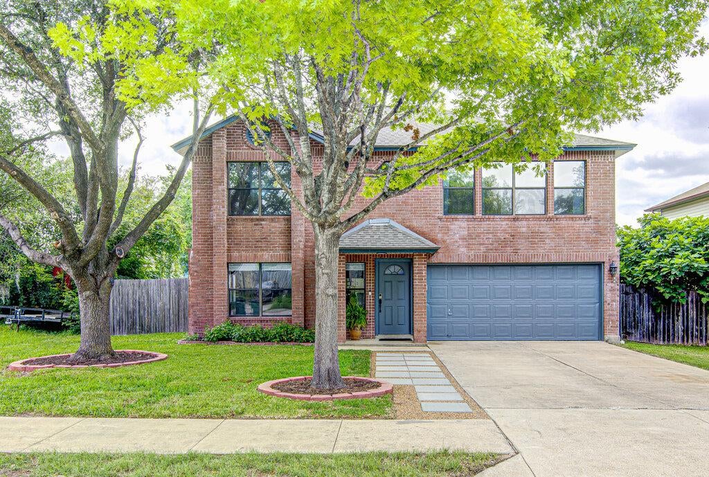 Brick facade residence featuring a two-car garage