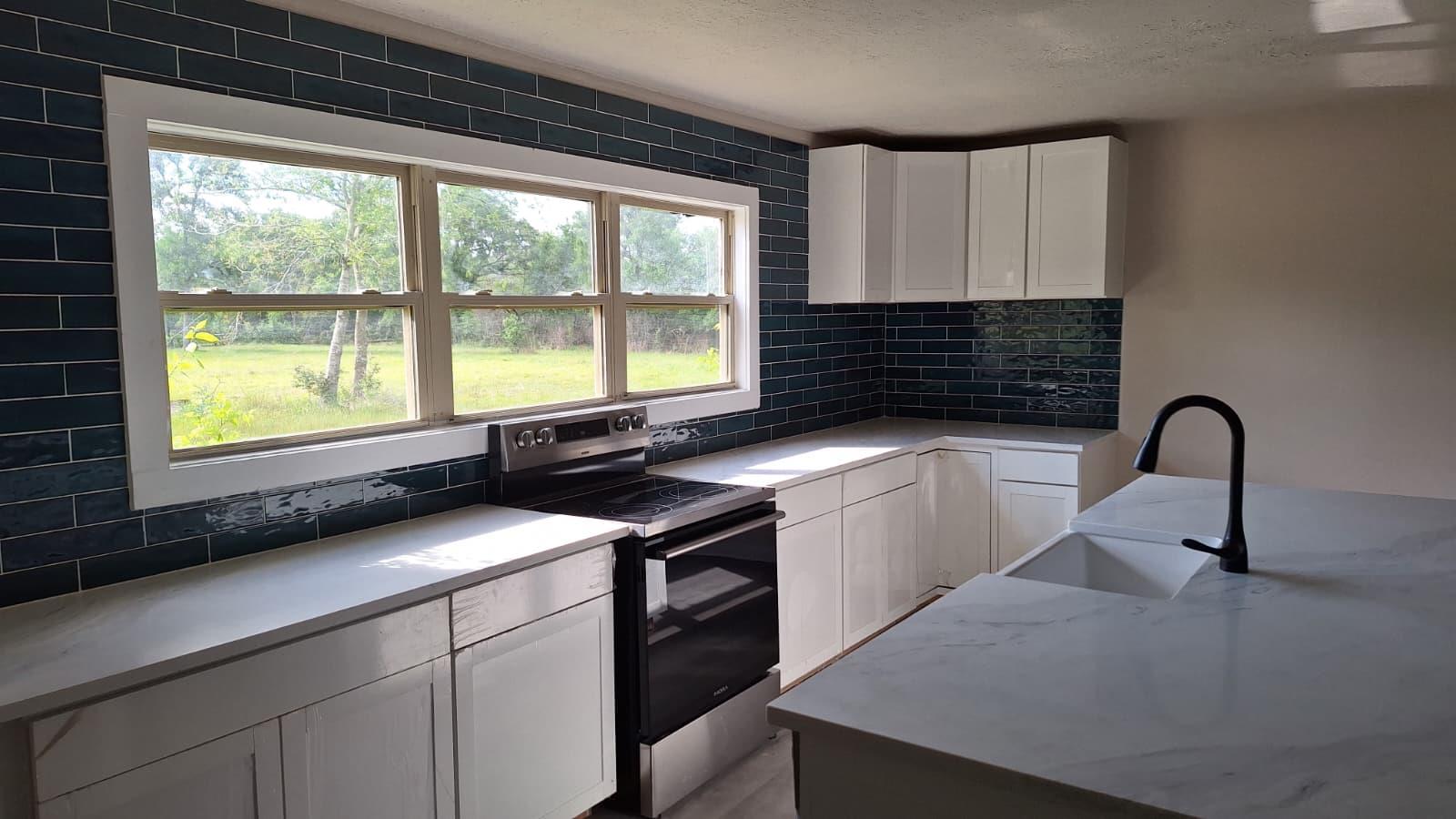 Kitchen featuring electric stove, white cabinetry