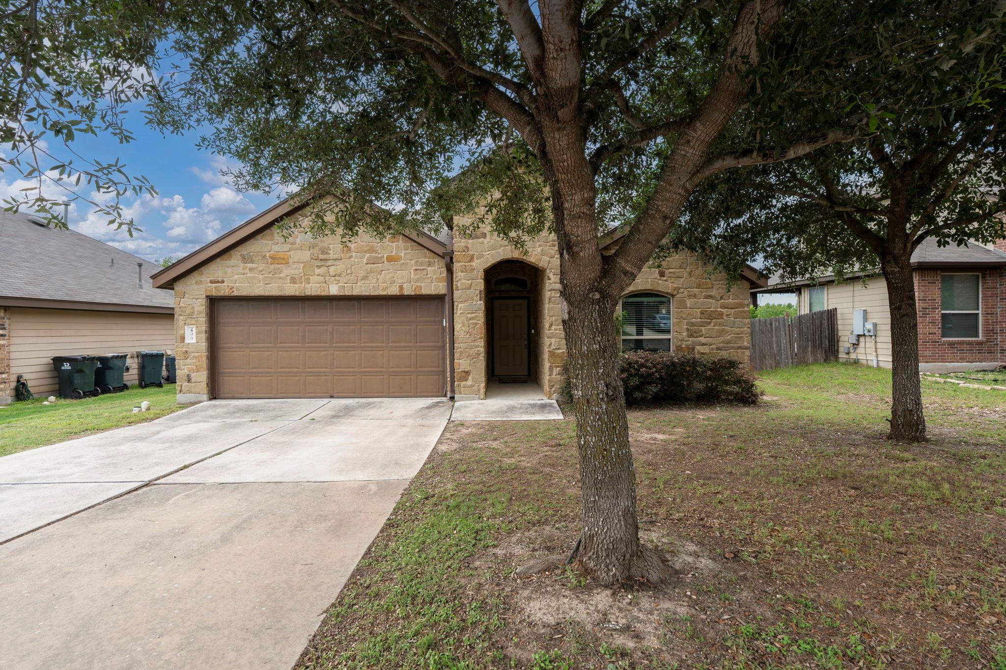 Stone fa?ade residence featuring an arched entryw