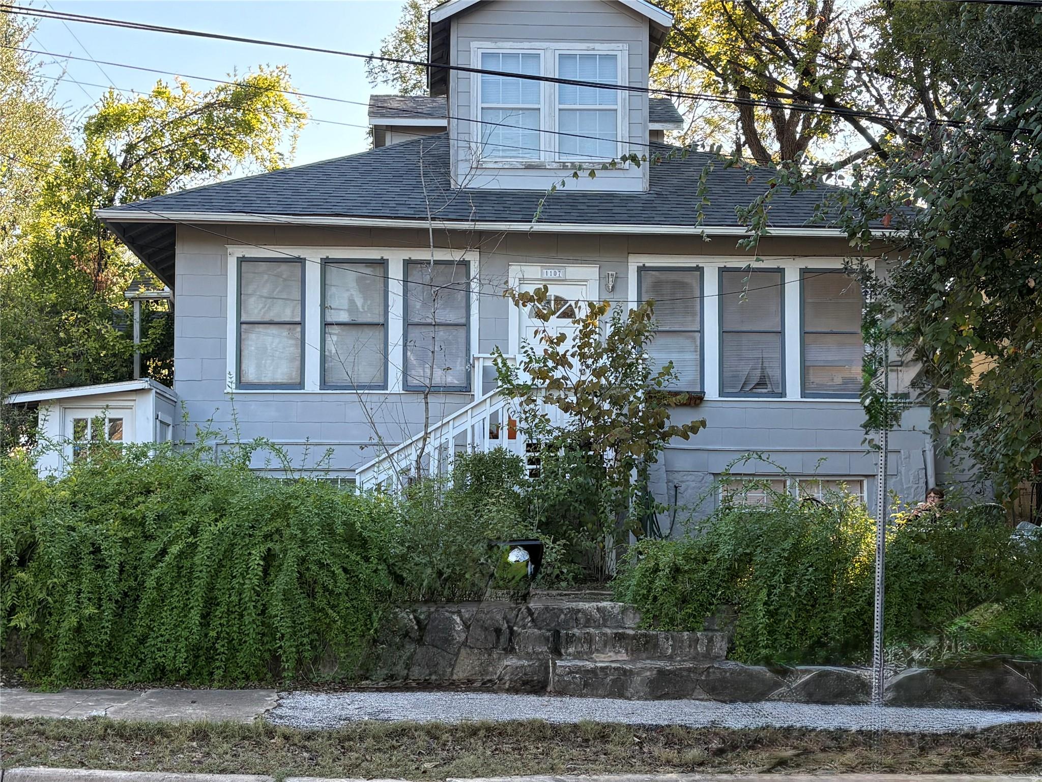 View of side of home featuring roof with shingles