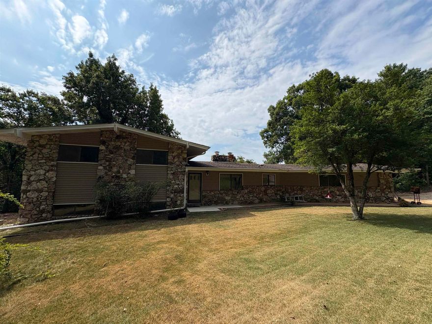 Discover your own private Ozark retreat on 42 surveyed acres with a year-round creek, natural springs, and winding riding trails. This spacious 4–5 bedroom, 3 bath home welcomes you into an expansive living room with massive windows framing open field and wildlife views—turkey and deer are frequent guests. Multiple fireplaces, including a handcrafted brick hearth in the kitchen, offer warmth and even cooking if the power’s out. The kitchen boasts abundant cabinets, double wall ovens, refrigerator, & dishwasher. Upstairs, the primary suite features a walk-in shower, private deck, and serene vistas. The lower level includes a family room with walk-out patio, additional bedrooms/office, and a full bath. Enjoy fiber internet, a two-car garage, and complete seclusion—hidden from the road, yet just 15 minutes to Hardy or Mammoth Spring. Whether you’re hunting, riding, or relaxing by Little Gut Creek, this property delivers the freedom and connection to nature you’ve been looking for.