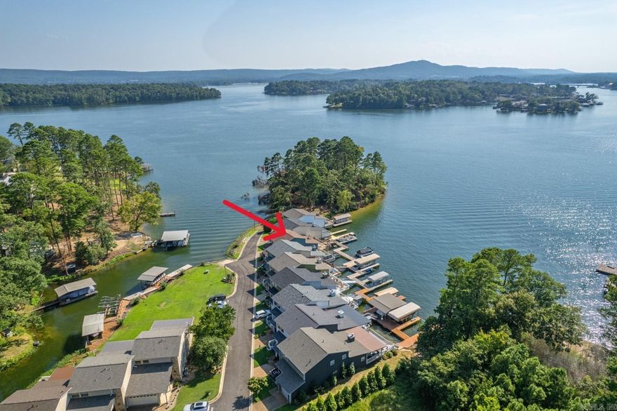 Seize this opportunity for high-style, Lake Hamilton living with front-row seats to vivid sunsets and dazzling holiday fireworks. The smart, open-concept floor plan maximizes views and engagement with seamless transitions between kitchen, dining, and living spaces. The Seller’s eye for design is reflected throughout the townhome with a modern, transitional aesthetic. Located on the walk-in level, the primary suite is a true retreat, featuring a magazine-worthy bathroom with a freestanding soaking tub, curbless tile shower, spacious walk-in closet, and an oversized bedroom with a view. Upstairs, you'll find two generously sized bedrooms—both water facing--connected by a Jack & Jill bathroom. The unique deck, built over the water, provides HUGE views and is perfect for entertaining, fishing, swimming, and keeping an eye on your boat. Files Landing is a gated townhouse community built on a peninsula and conveniently located off 7 South. **NO NIGHTLY RENTALS ensures your peace and enjoyment.**
