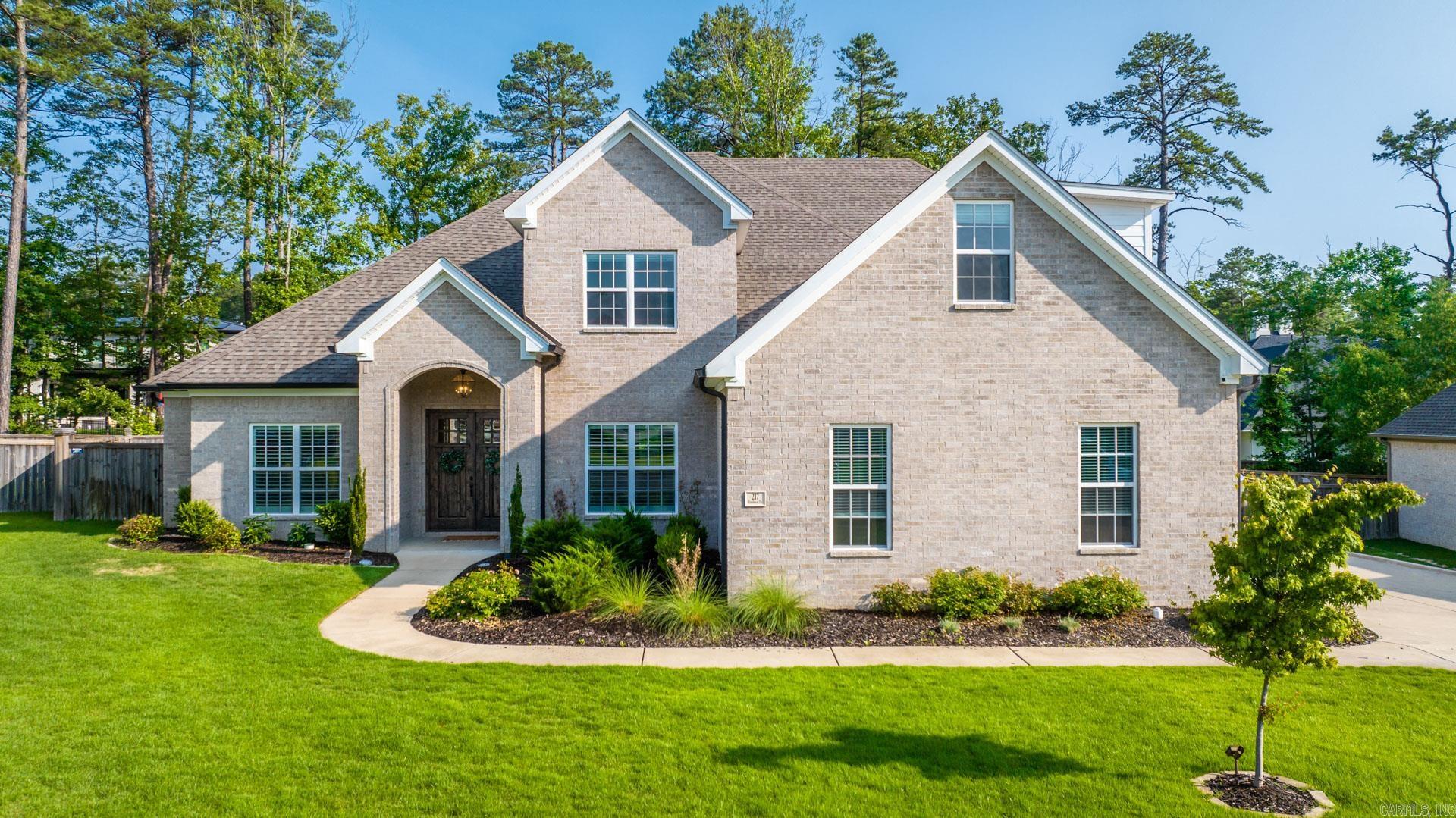 This is a custom 4 Bed 3.5 Bath with an office on a great exterior lot inside the golf course accessible Ensbury of Chenal. Inside, you’re welcomed with tall wood beamed ceilings & all new LVP floors atop true hardwoods throughout. Enter your beautifully open plan with the large dining to the right into your spacious living with the gas log fire. Your kitchen highlights the quartzite breakfast island with a carbon filtered farm sink, a big breakfast area, a built-in gas stove, and walk-in pantry. Step out to your immaculate covered veranda with the wood burning fire wrapped with motorized shades to screen in the porch. The large and level backyard is fully fenced with a playground setup. Privately set apart on the main level to the left of the foyer is the office & primary suite with the walk-in seated rain shower, free-standing soaker tub, double vanity, and big walk-in closet.Also on the main level is the private guest suite. Every bedroom has blackout blinds and walk-in closets and each bathroom has automated lighting upon entry. From the 3-car side entry garage (with the incredible storage solutions built-in) - is the locker station, a private half bath, and convenient laundry.