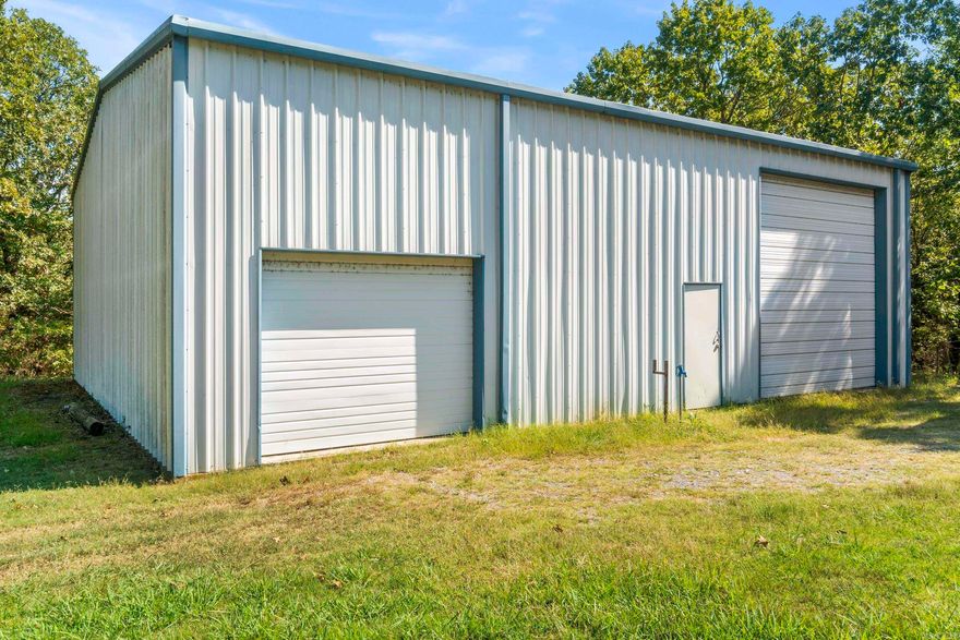 Looking for peaceful country living with space to spread out? This property offers nearly 20 acres outside the city limits with no restrictions, giving you the freedom to build your dream home or place a new mobile home. Utilities are already in place — water, septic, and electric are installed and ready to go. The property has its own driveway and another driveway on the other side for convenience. Also, much of the land is wooded, making it an ideal spot for hunting or creating your private retreat. A 50x45 shop with two large garage doors, electricity, front and back doors is included and features a half bathroom that’s already connected to the septic system — 1/2-bathroom does need finished out. Enjoy peace, privacy, and endless possibilities with this one-of-a-kind property! There is another flat spot on the land down from the shop that could be a great spot for a home, but someone would need to work on utilities for that spot. Seasonal creek runs on the property! Beautiful trees! Mineral rights do not convey. The current mobile home can be removed before closing, and all items in the shop and equipment on the land will be removed from the property prior to closing.