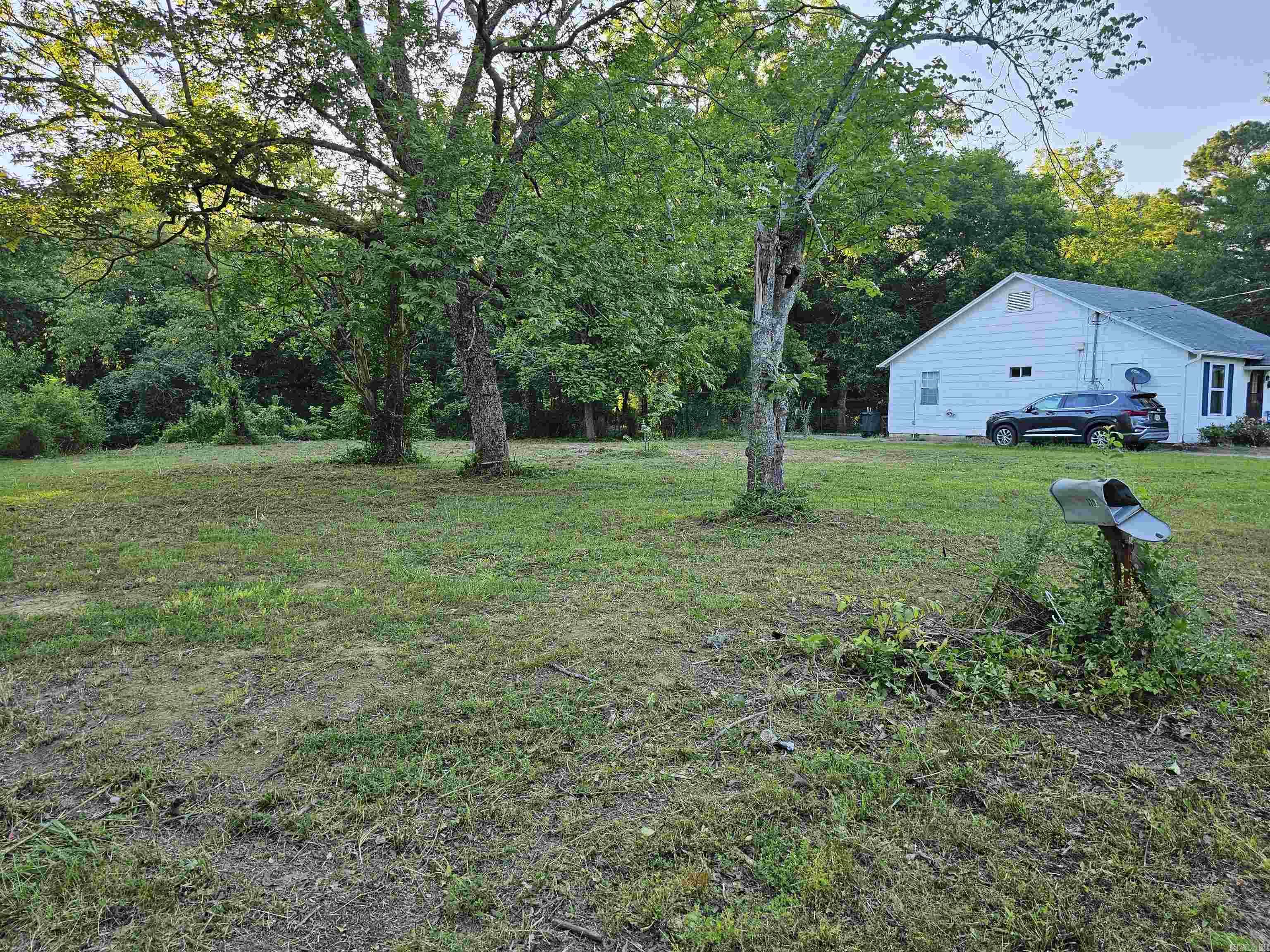 Cleared lot WITH CITY UTILITIES and large shade trees. Would be perfect for a starter home or a rental. Close to downtown Mena, Ar, Wolf Pen Gap trails and the scenic Wilhelmina Drive. Agents see remarks.