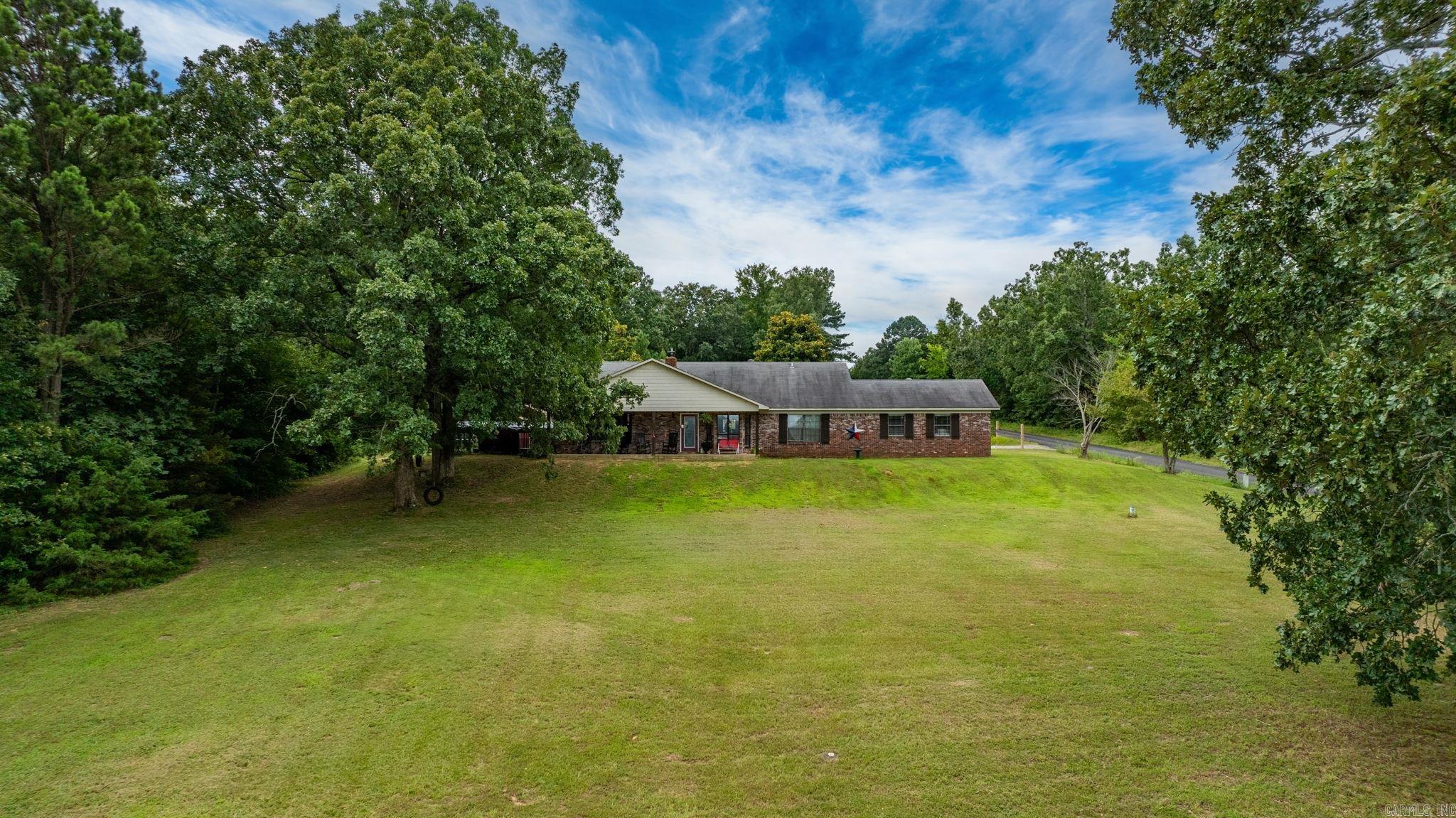 What a spectacular view with lots of privacy! This home sits atop a hill with a view of the valley below. There are no homes close this one and it has trees on three sides. The living and kitchen are very large and open to each other for an expansive feeling. Large island and extra countertop space and cabinetry. Huge laundry room with a door to the backyard. The half bath is just off the laundry room. The bedrooms are all very spacious with good size closets especially the very back bedroom with a large walk in closet. The primary bedroom also has a walk in closet. At one time there was a mobile home at the back of the property so it would be easy to use that area for a second home. The current owner had it fenced for horses. There is a large barn that could be used as a great workshop or storage area or continue using as a barn. The chicken coop will remain. No restrictions on this property. Enjoy sitting on the front porch taking in the view with a morning coffee or an evening sunset. There are so many possibilities with this home.