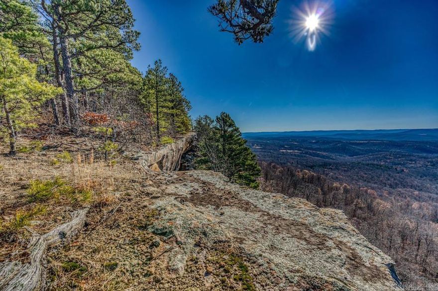 What a special and remarkable dual-purpose farm with established pasture, wonderful timber, and a massive sheer bluffline. This unique property is full of options for the farmer, the hunter, or even the investor, with unlimited cabin-building sites for short-term rentals. The location is ideal, being just a few minutes outside of Harrison, AR, near the headwaters of the Buffalo National River at Ponca, AR. Conveniently accessed by an easement road just over 1/2 mile off the paved country highway, there are no issues for your building dreams, bringing in hay equipment, cattle trailers, or any other venture. Being in such close proximity to the Buffalo National River really opens up the options you have for short-term rentals. The layout of the tract is a combination of a massive flat ridge that is covered in quality grasses and some towering sheer cliffs on both the East and West sides of the land. Pockets of hardwood and pine timber are layered in sections of deep ravines that meador over the bluffs. Without question, the star of the show is the impressive bluffs that offer some of the most dramatic and breathtaking views in the entire region.