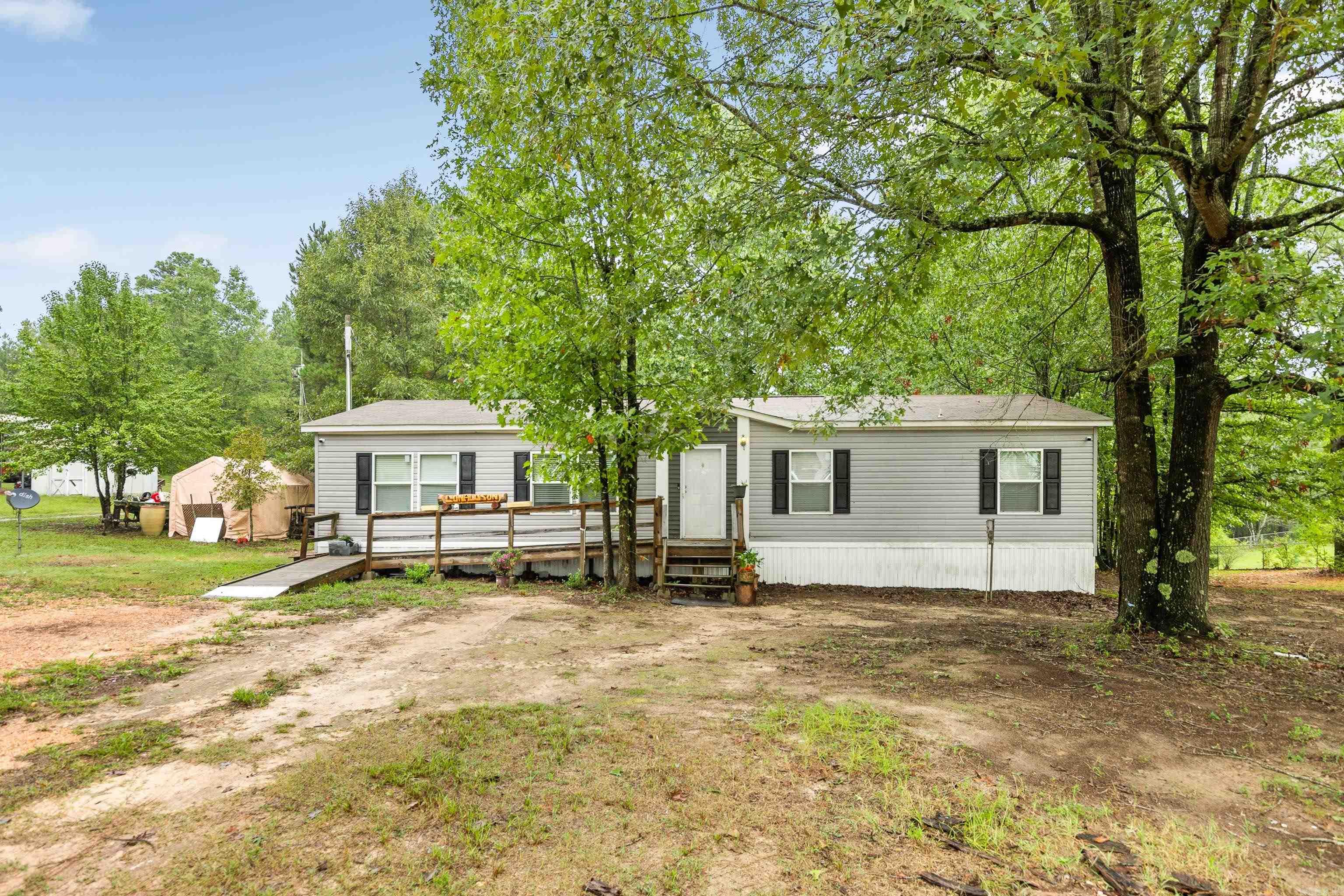 Charming and well-maintained manufactured home nestled on a spacious 1-acre lot in the peaceful countryside, within the sought-after Bauxite School District. This home features a beautifully updated modern interior, including a large master suite with a luxurious soaking tub and separate shower. The spacious kitchen offers a walk-in pantry, island, and dining space. Additional highlights include walk-in closets in the bedrooms and a convenient laundry room with counter space. Enjoy the fenced backyard, perfect for pets or outdoor gatherings, along with a storage shed for extra storage.
