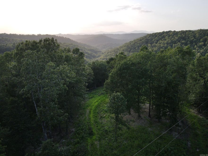 This excellent building tract is loaded with features. An excellent location with close proximity to the Buffalo National River and many other area attractions. Located on a well-maintained gravel county road, the access is comfortable, and a building site is already cleared. This tract boasts electric service on-site, rural water, and some massive mountain vista views that are truly breathtaking. The rolling topography lends itself to privacy, beauty, and excellent hunting opportunities for the resident deer, turkey, black bear, and even occasional hogs. The area is prime and loaded for an investment opportunity for building one or multiple cabins for Airbnb or VRBO, as it is so close to many regional attractions, including but not limited to; hiking, camping, kayaking, canoeing, public hunting, and more! The public access points on the Buffalo River and public hunting on the National Forest areas are just a few short minutes away and offer ample opportunities for that family getaway, hunting camp escape, or rental investment. Woolum, Carver, and Hasty access are all right there, close by. The hardwood (predominately Red Oak) and pine mix on the land create a tranquil place.