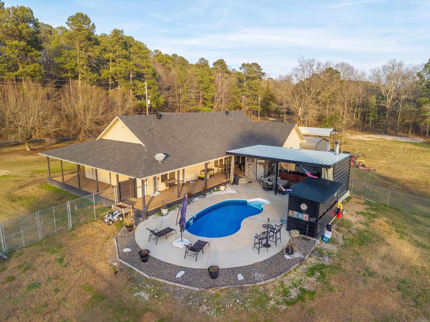 Stylish, classy, beautiful countryside living at it's best! This gorgeous home with 18' ceilings, designed concrete flooring, large rock fireplace, open floor plan on the inside, then opens up to a dreamy outdoor kitchen area with another fireplace and a tv for entertaining guest who can also enjoy the welcoming in-ground heated, saltwater pool. The  heated/cooled detached garage and is the perfect work space,  where the owner has rebuilt many beautiful classic cars or for any other workshop area you may want.  All of this sits on beautiful 2 acres where you can enjoy other outdoor activities or a place to park your boat, rv or any other toys.  The back yard is fenced in to keep your fur babies safe, yet they have plenty of room to play.